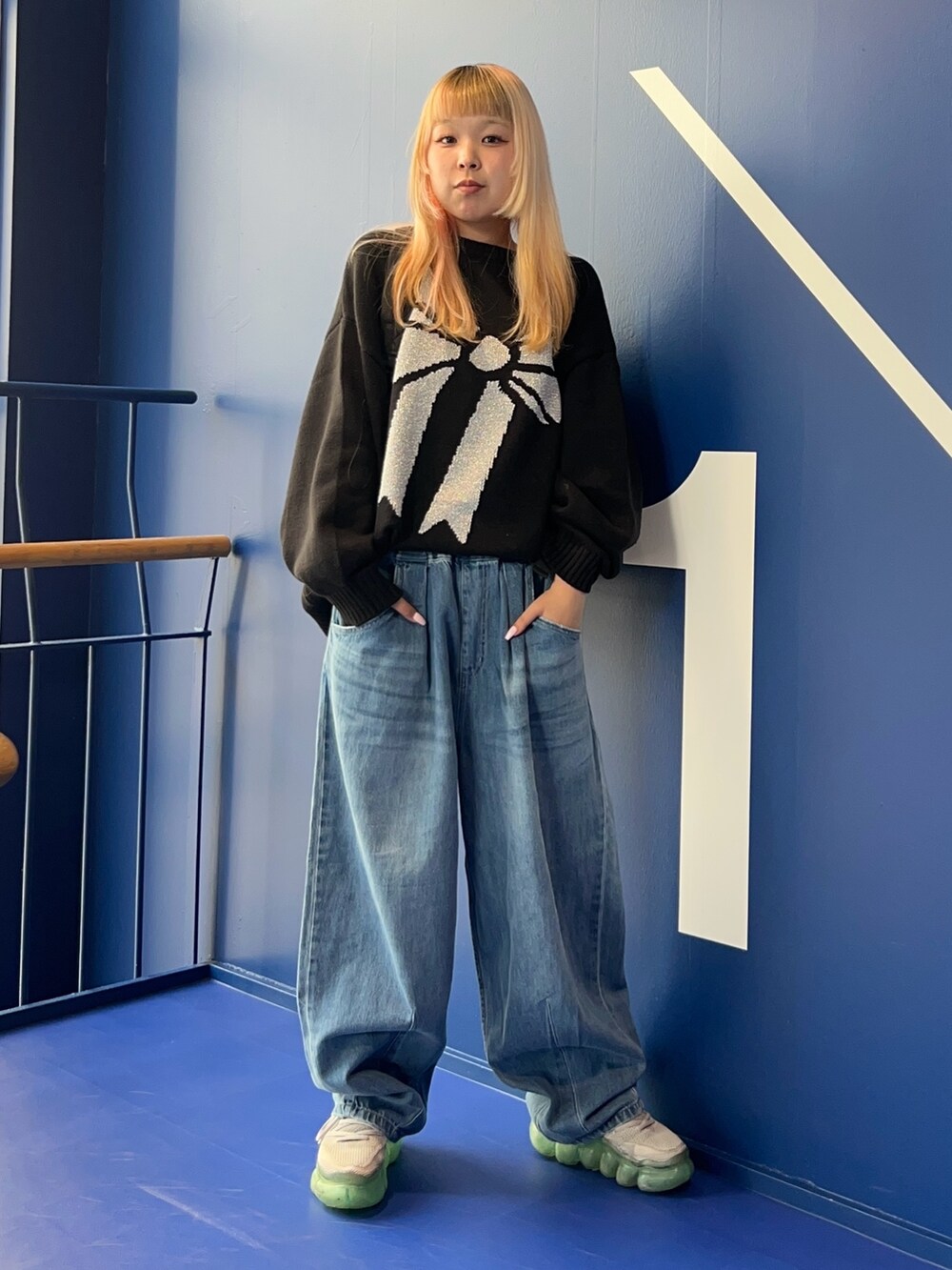 ブラック系のニット/セーター、ブルー系のデニムパンツ、ブラック系のバックパック/リュックを着用したレディースの秋コーディネートの3枚目の写真