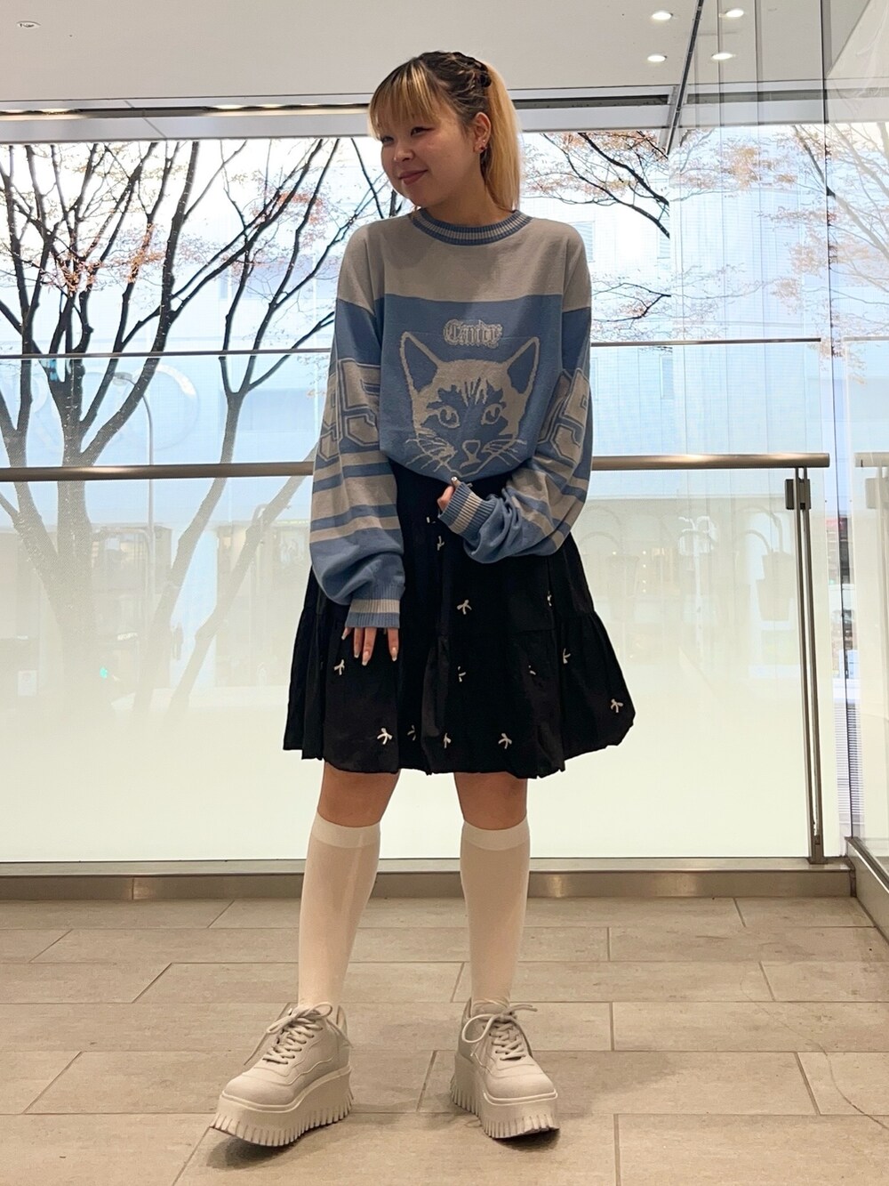 ブラック系のスカート、ブルー系のニット/セーター、ブラック系のダウンジャケット/コートを着用したレディースの冬コーディネートの4枚目の写真