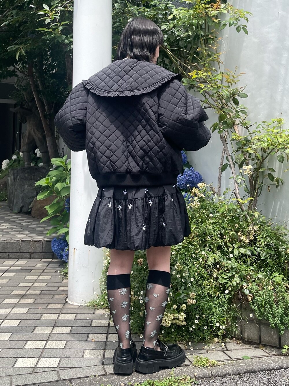 ブラック系のスカート、ブラック系のその他アウター、ブラック系のローファーを着用したレディースの冬コーディネートの3枚目の写真