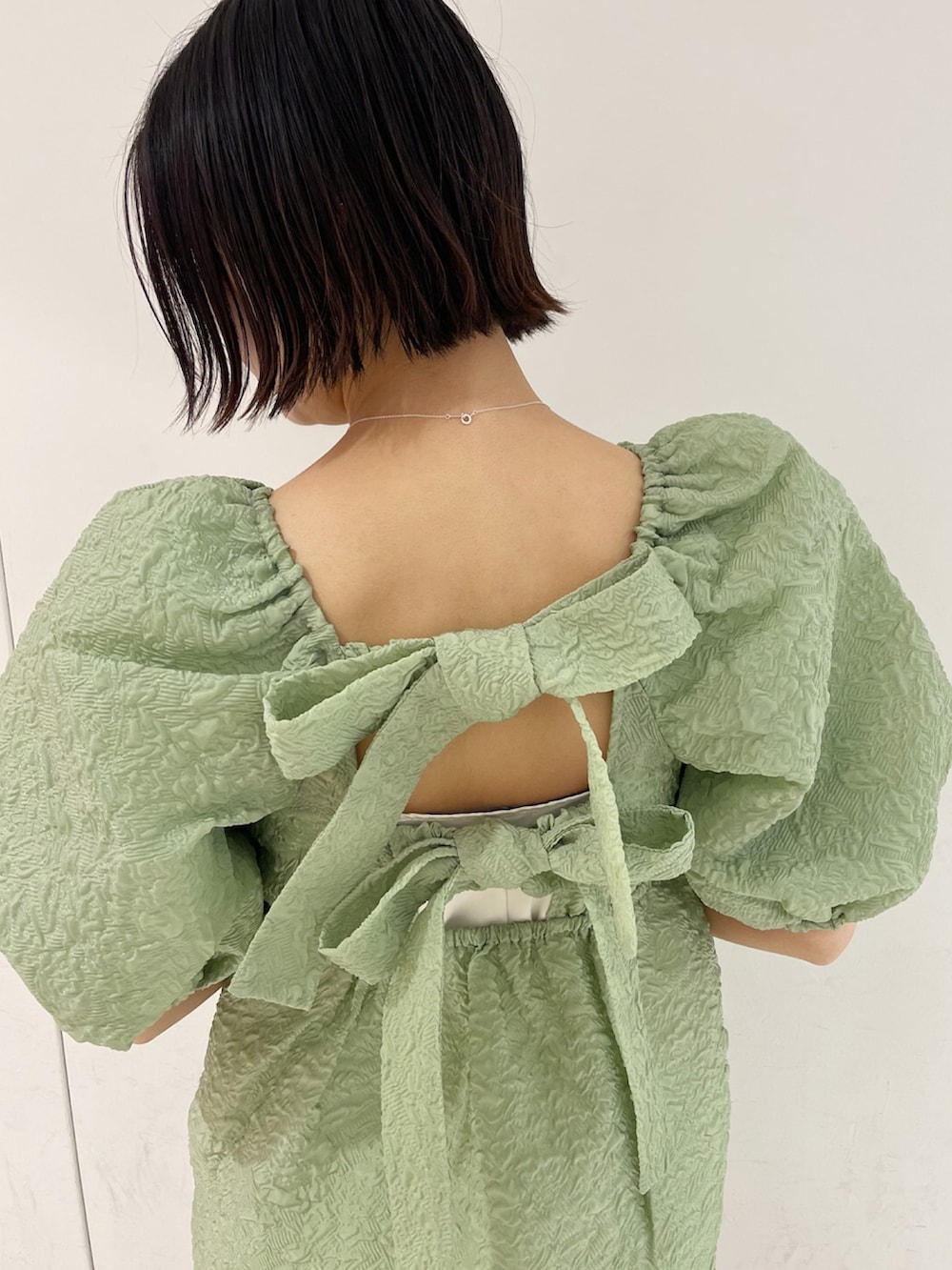 ブラック系のシューズ、グリーン系のシャツワンピースを着用したレディースの春コーディネートの3枚目の写真