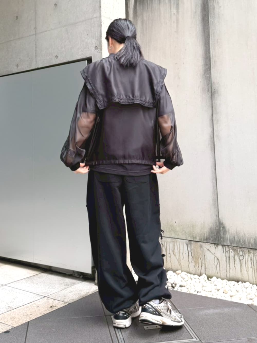 ブラック系のスウェットパンツ、ブラック系のブルゾン、ブラック系のTシャツ/カットソーを着用したレディースの春コーディネートの3枚目の写真