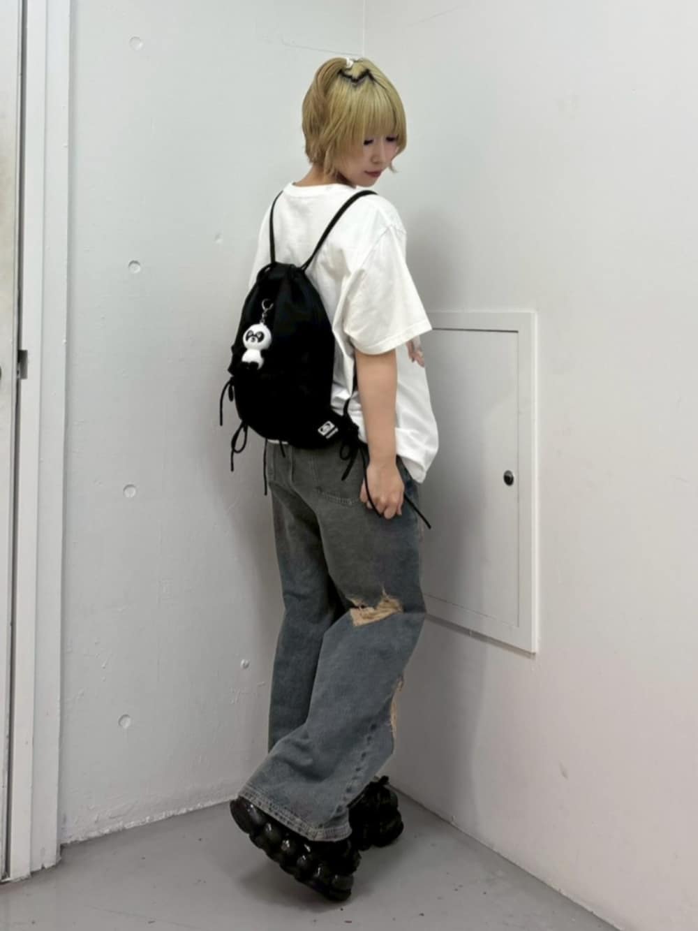 ブルー系のデニムパンツ、ホワイト系のTシャツ/カットソー、ブラック系のバックパック/リュックを着用したレディースの夏コーディネートの3枚目の写真