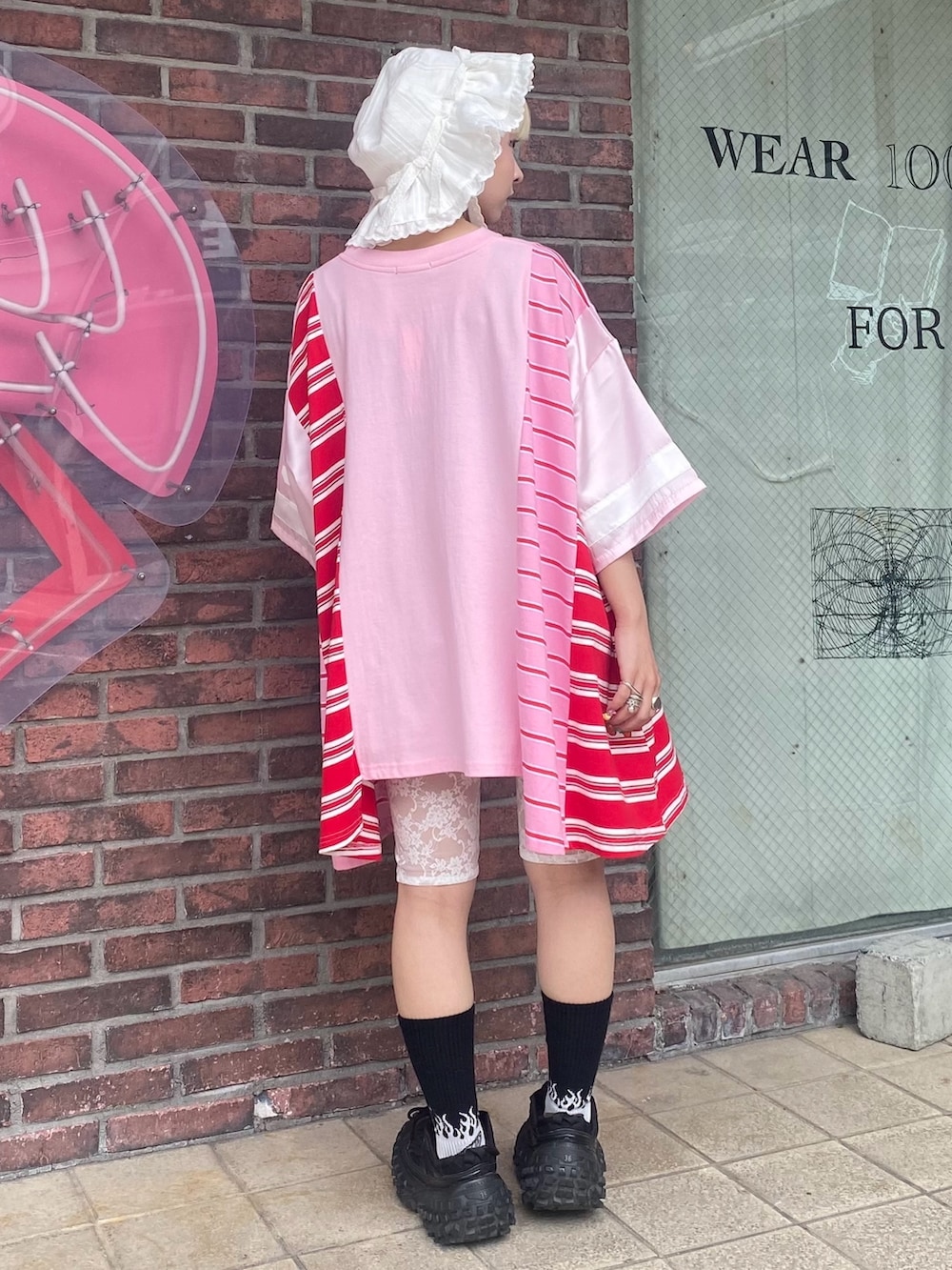 レッド系のその他パンツ、ピンク系のTシャツ/カットソー、ホワイト系のハットを着用したレディースの夏コーディネートの5枚目の写真