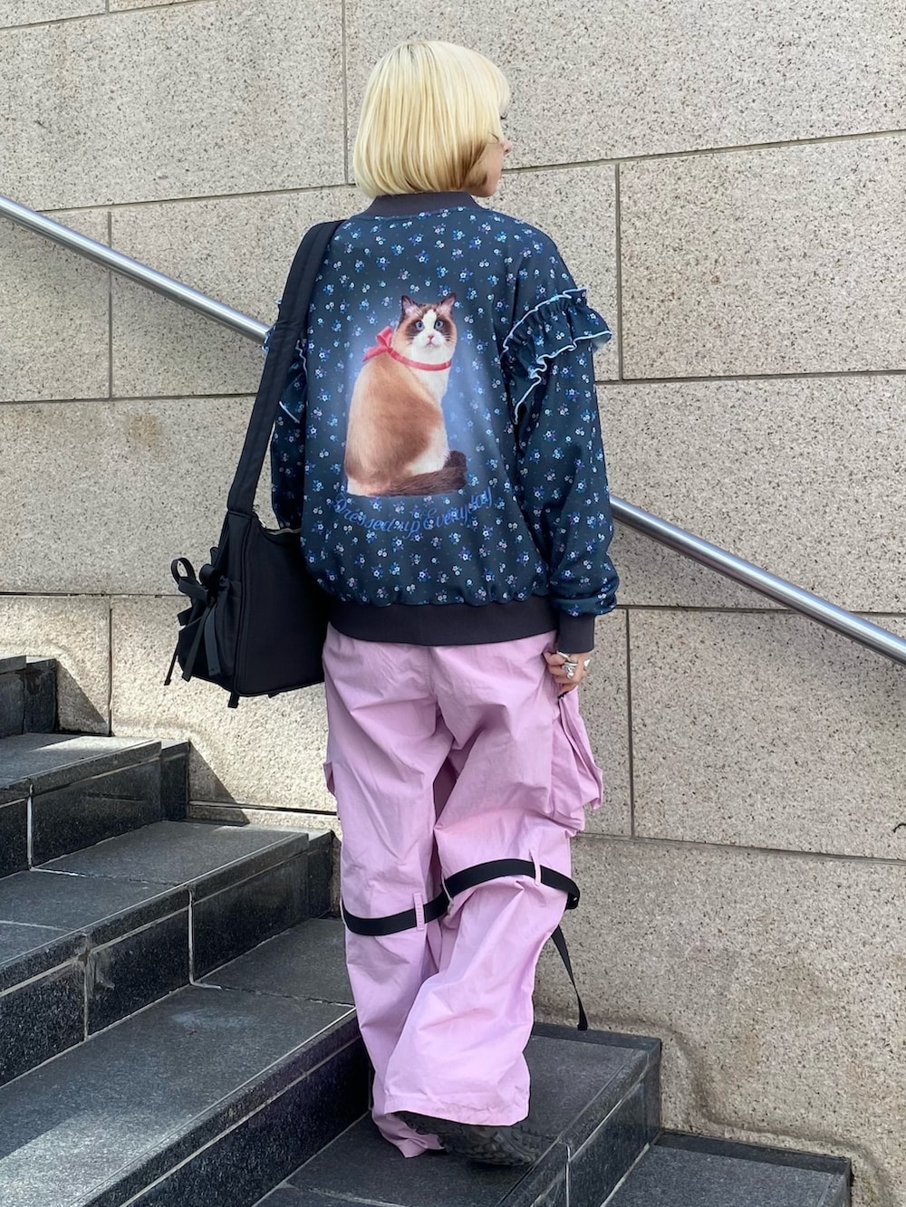 ブラック系のブルゾン、ピンク系のTシャツ/カットソー、ピンク系のカーゴパンツを着用したレディースの春コーディネートの5枚目の写真