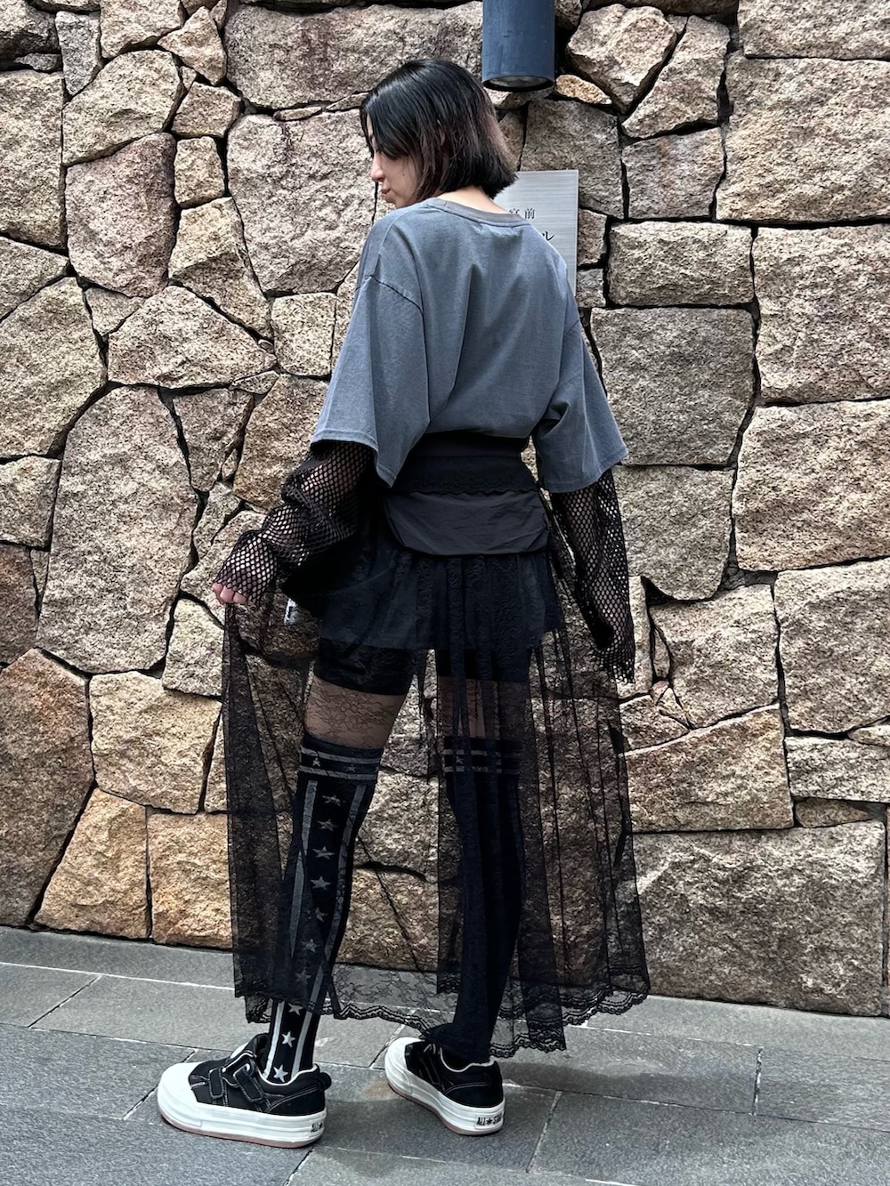 グレー系のTシャツ/カットソー、ブラック系のスカート、ブラック系のソックス/靴下を着用したレディースの春コーディネートの6枚目の写真