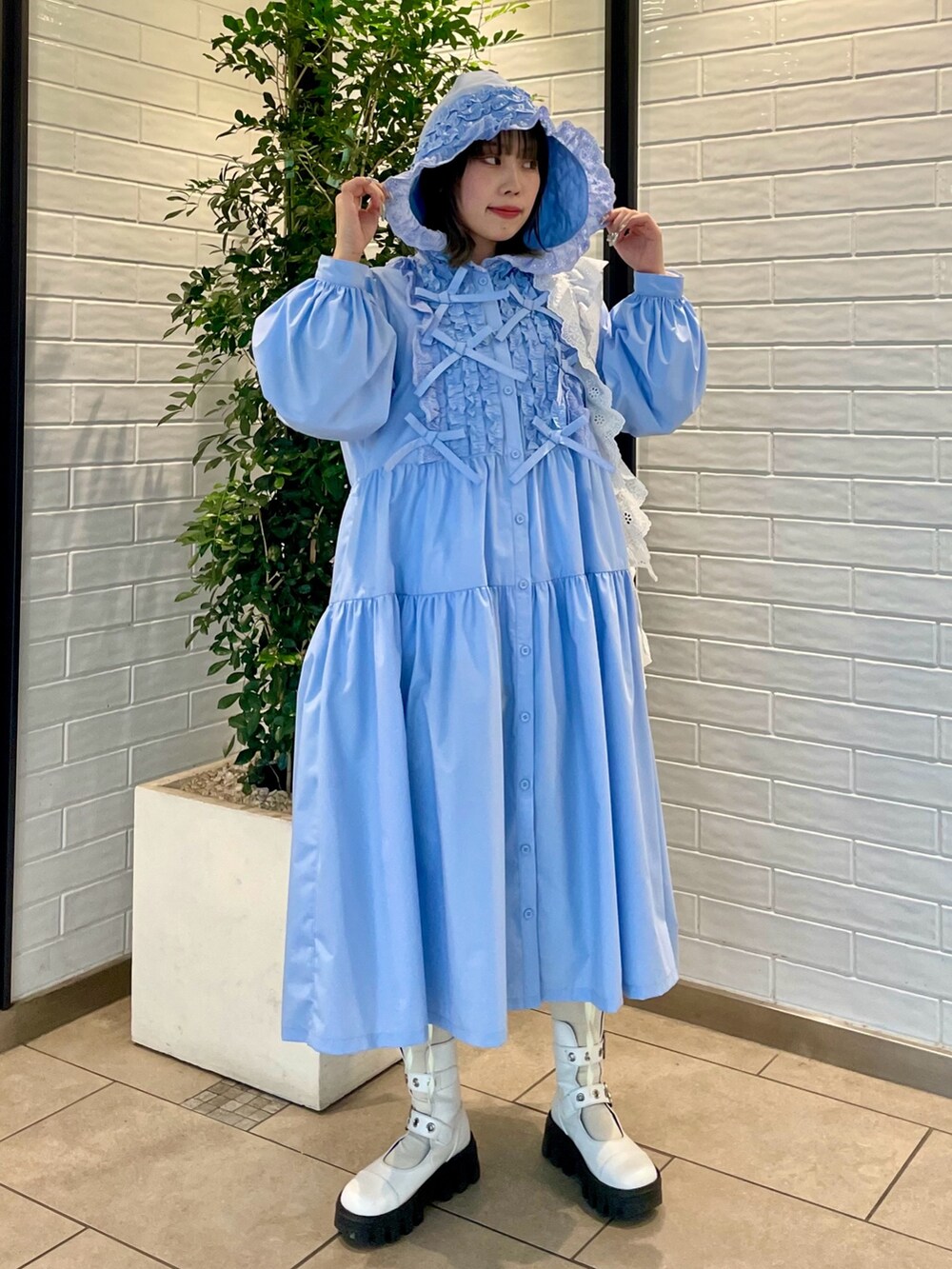 ブルー系のワンピース、ホワイト系のショルダーバッグ、ホワイト系のブーツを着用したレディースの冬コーディネートの3枚目の写真