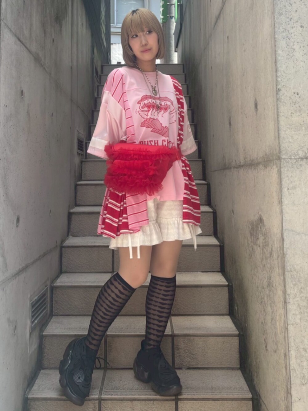 ピンク系のTシャツ/カットソー、ホワイト系のその他パンツ、レッド系のボディバッグ/ウエストポーチを着用したレディースの夏コーディネートの2枚目の写真