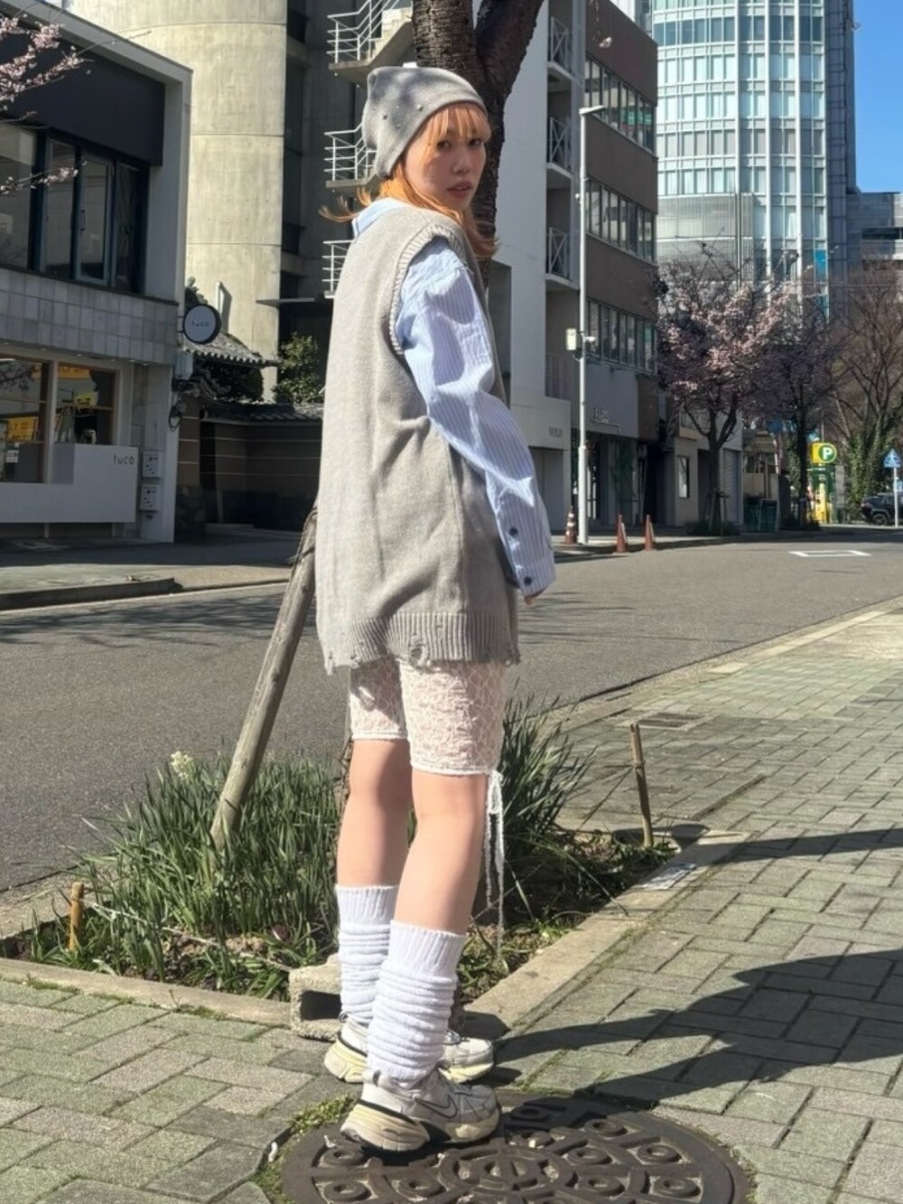 グレー系のベスト、ブルー系のシャツ/ブラウス、ホワイト系のその他パンツを着用したレディースの春コーディネートの3枚目の写真