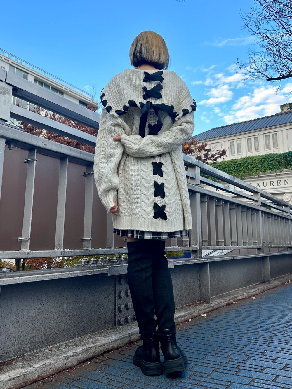 ホワイト系のその他アウター、ホワイト系のニット/セーター、ブラック系のスカートを着用したレディースの冬コーディネートの5枚目の写真