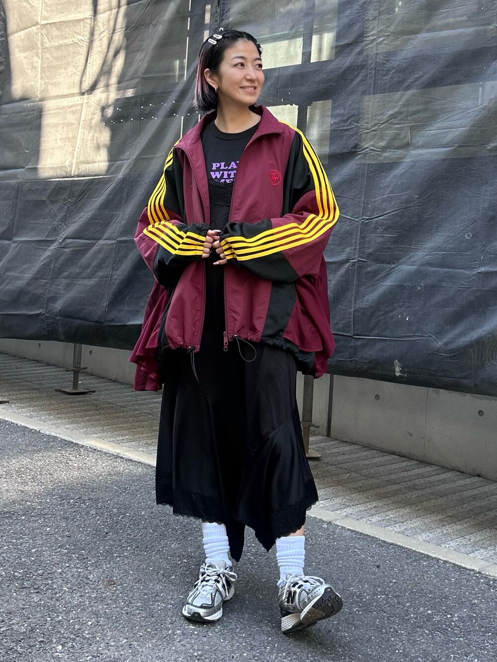 レッド系のブルゾン、ホワイト系のTシャツ/カットソー、ブラック系のワンピースを着用したレディースの冬コーディネートの2枚目の写真