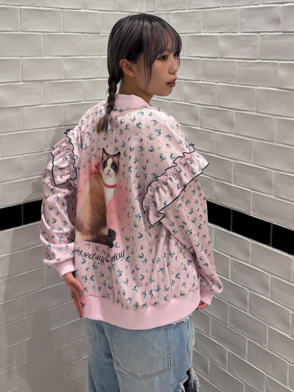 ブルー系のデニムパンツ、ホワイト系のスカート、ホワイト系のTシャツ/カットソーを着用したレディースの春コーディネートの5枚目の写真