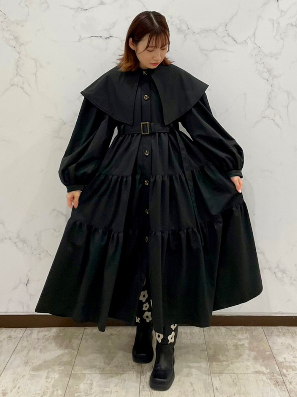 ブラック系のトレンチコート、ブラック系のブーツを着用したレディースの冬コーディネートの2枚目の写真