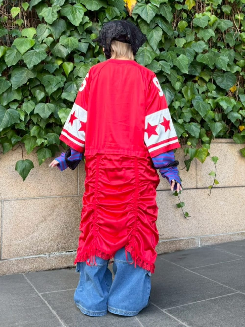 ブルー系のデニムパンツ、レッド系のワンピース、パープル系のTシャツ/カットソーを着用したレディースの冬コーディネートの3枚目の写真