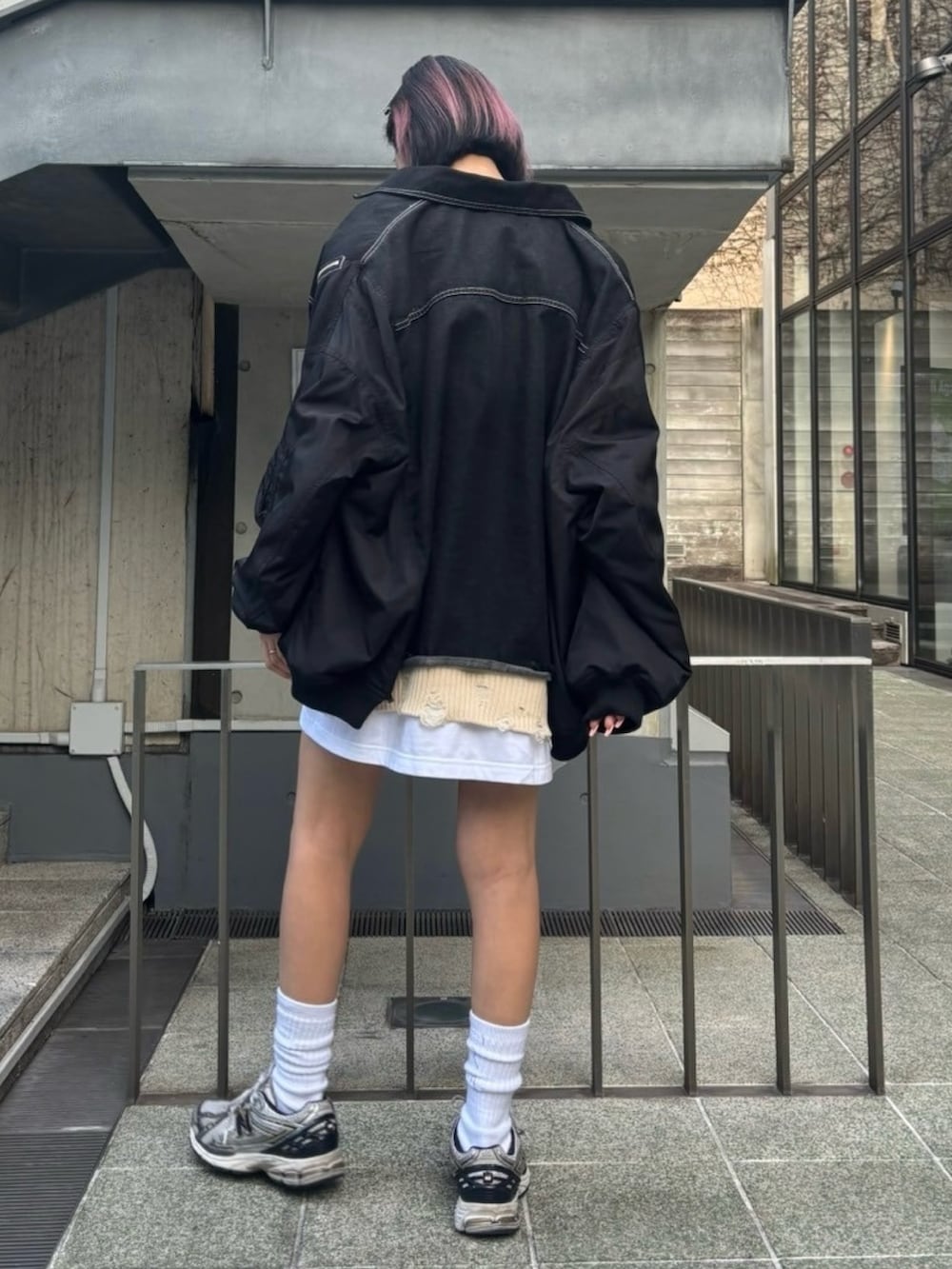 ブラック系のデニムジャケット、ホワイト系のベスト、ホワイト系のTシャツ/カットソーを着用したレディースの冬コーディネートの4枚目の写真