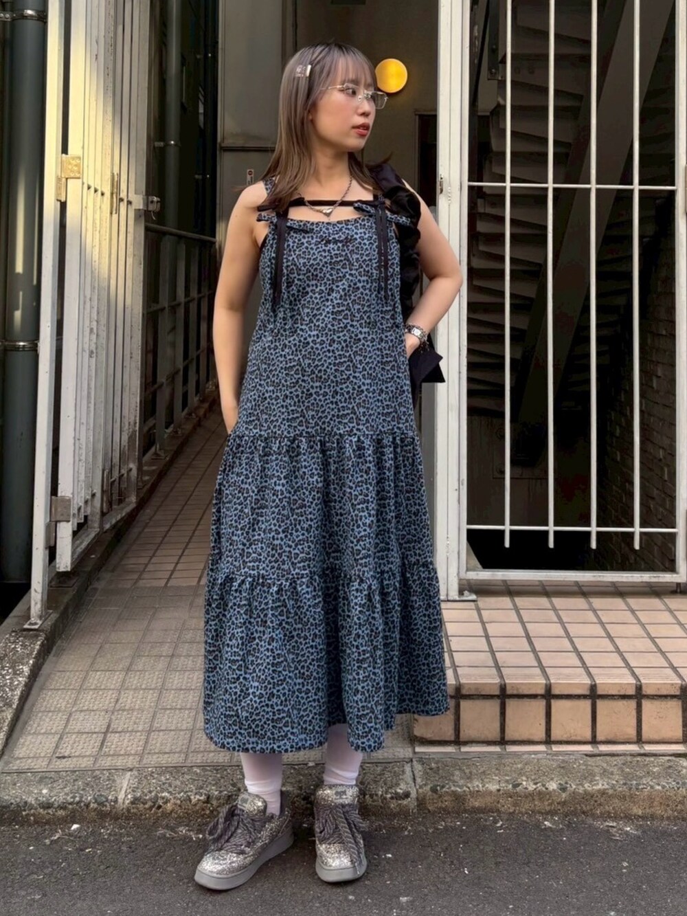 ブラック系のショルダーバッグ、ブラック系のキャミソール、ブルー系のワンピースを着用したレディースの春コーディネートの2枚目の写真