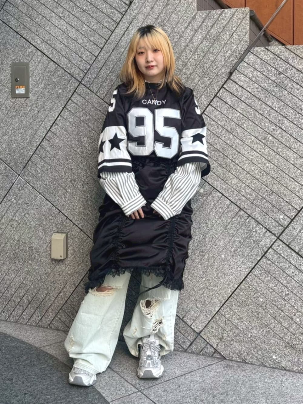 ブラック系のワンピース、グレー系のシャツ/ブラウス、ブルー系のデニムパンツを着用したレディースの春コーディネートの2枚目の写真