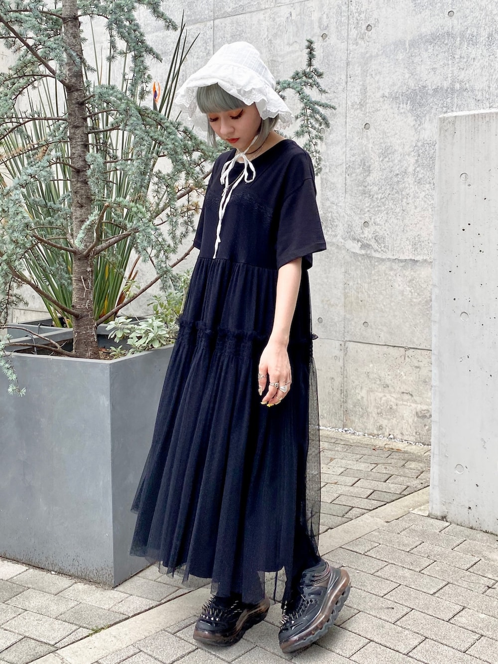 ブラック系のワンピース、ホワイト系のハットを着用したレディースの春コーディネートの3枚目の写真