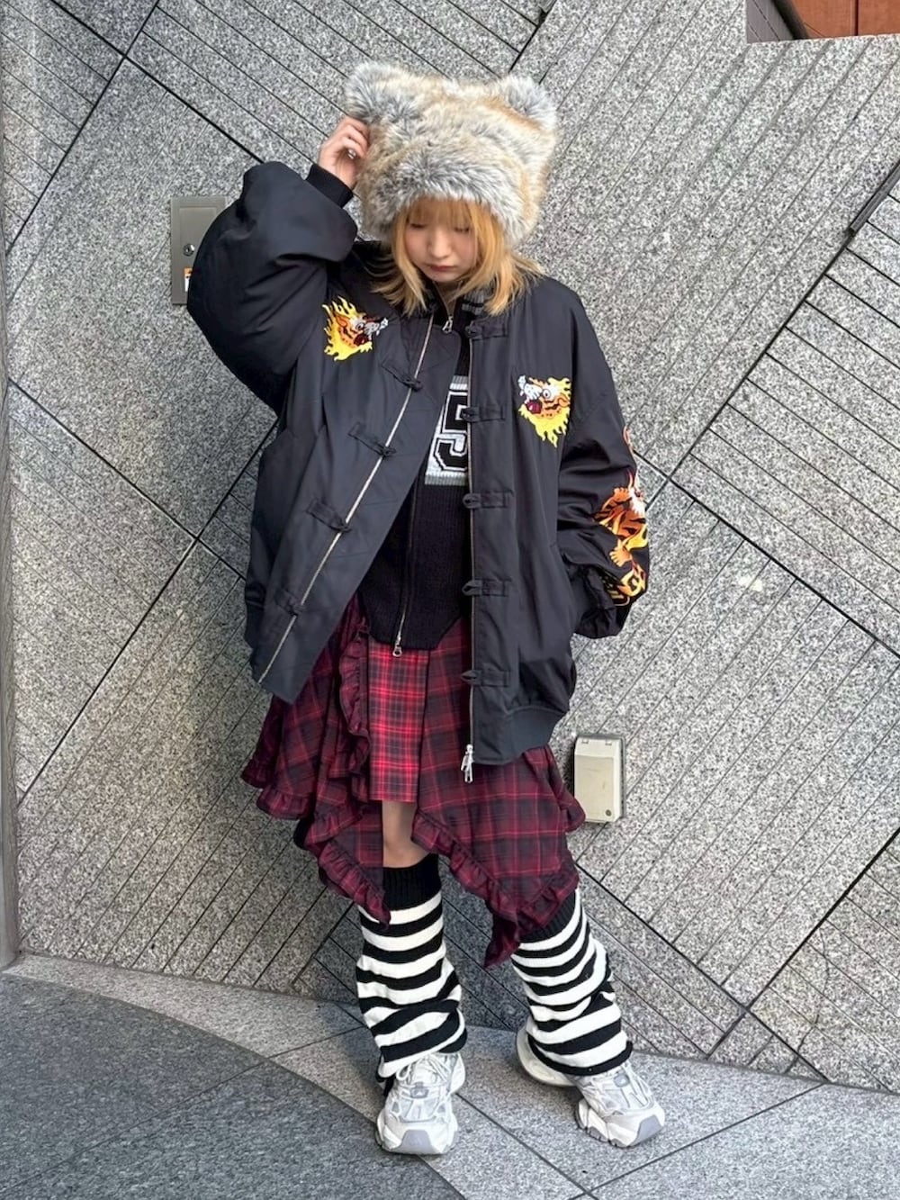 レッド系のワンピース、ブラック系のニット/セーター、ブラック系のMA-1を着用したレディースの秋コーディネートの2枚目の写真