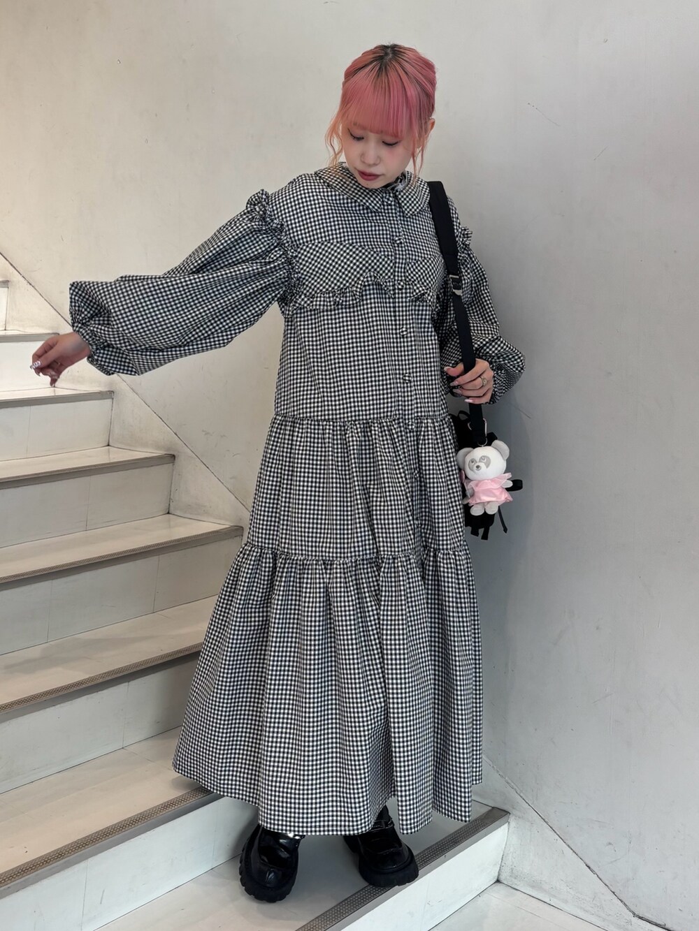 ブラック系のローファー、ブラック系のショルダーバッグ、ホワイト系のワンピースを着用したレディースの冬コーディネートの2枚目の写真