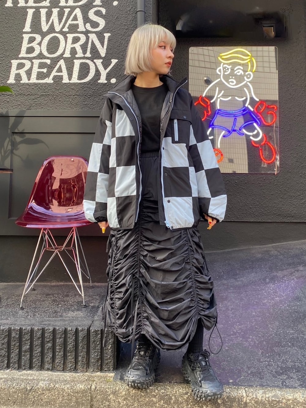 ブラック系のスカート、ブラック系のダウンジャケット/コート、ブラック系のTシャツ/カットソーを着用したレディースの秋コーディネートの2枚目の写真