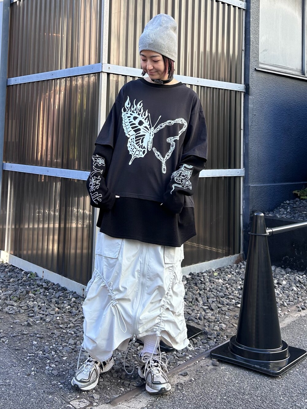 ブラック系のTシャツ/カットソー、ホワイト系のスカート、シルバー系のシューズを着用したレディースの春コーディネートの3枚目の写真