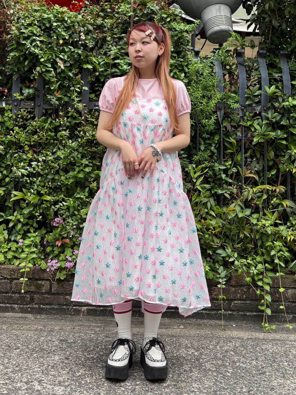 ピンク系のワンピース、ピンク系のTシャツ/カットソー、ブラック系のショルダーバッグを着用したレディースの夏コーディネートの2枚目の写真