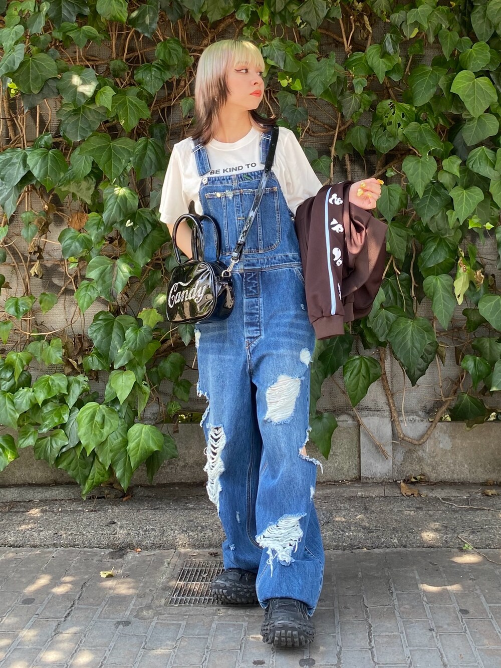 ブラック系のボストンバッグ、ブルー系のサロペット/オーバーオール、ホワイト系のTシャツ/カットソーを着用したレディースの夏コーディネートの4枚目の写真