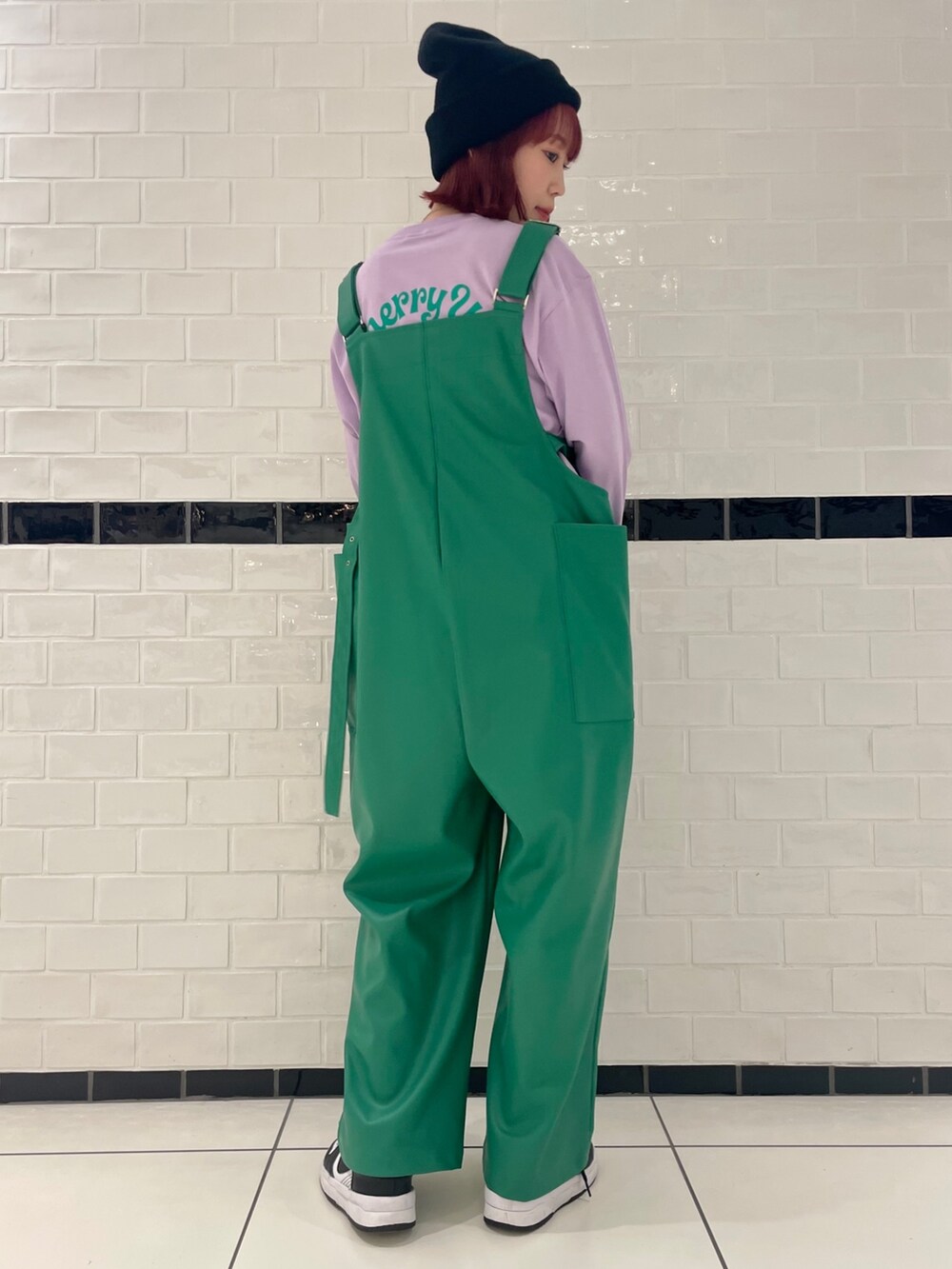 パープル系のTシャツ/カットソー、グリーン系のサロペット/オーバーオール、ブラック系のニットキャップ/ビーニーを着用したレディースの冬コーディネートの3枚目の写真