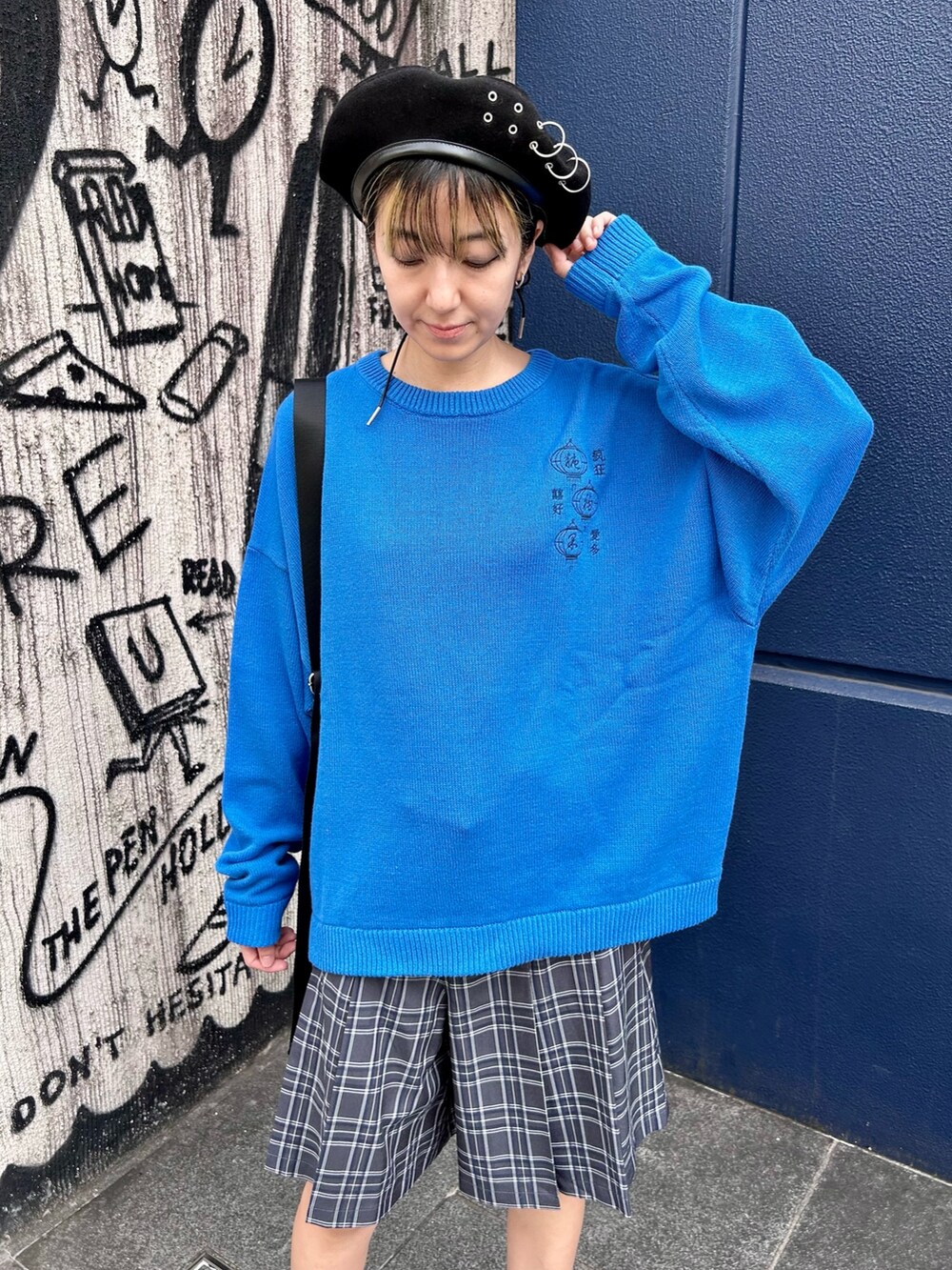 ブルー系のニット/セーター、グレー系のスカート、ブラック系のボディバッグ/ウエストポーチを着用したレディースの秋コーディネートの4枚目の写真