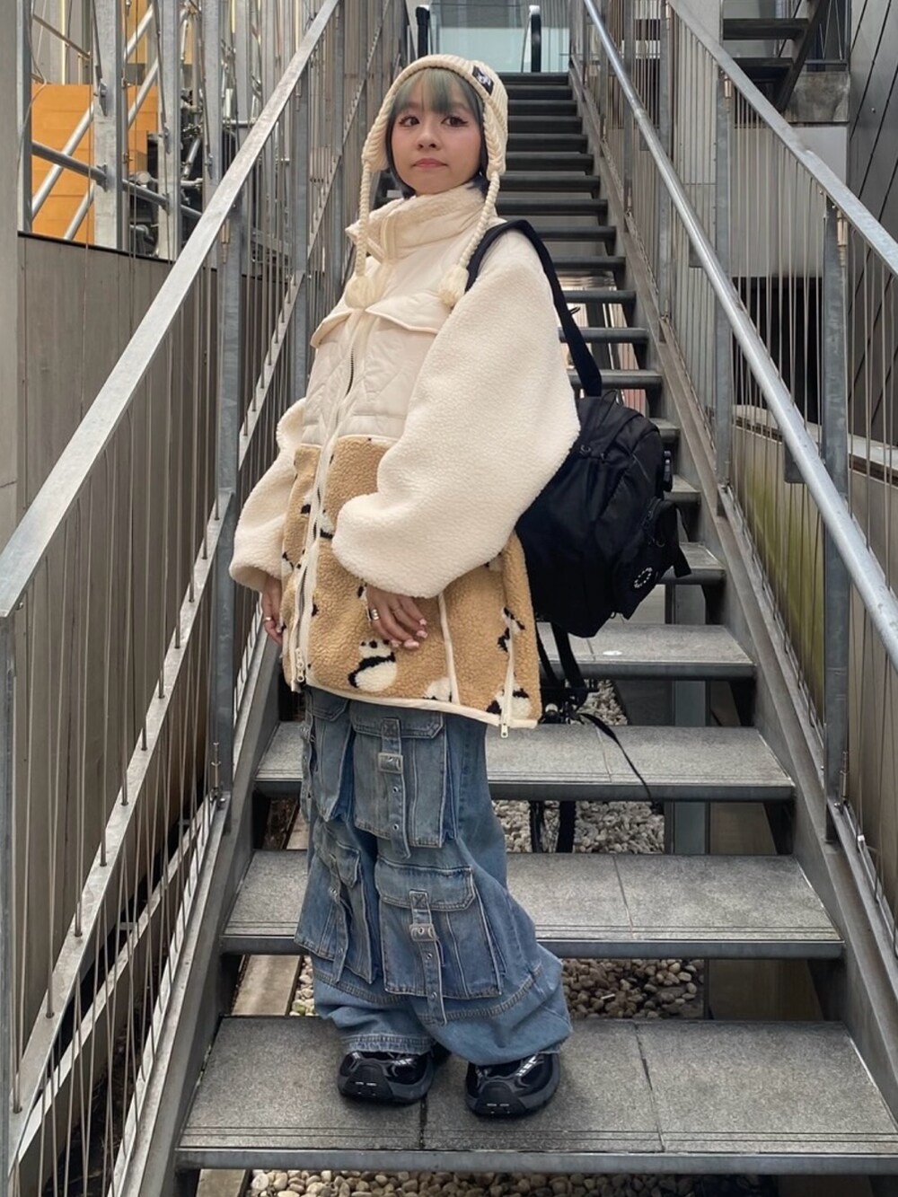 ホワイト系のダウンジャケット/コート、ブルー系のデニムパンツ、ホワイト系のニットキャップ/ビーニーを着用したレディースの秋コーディネートの4枚目の写真