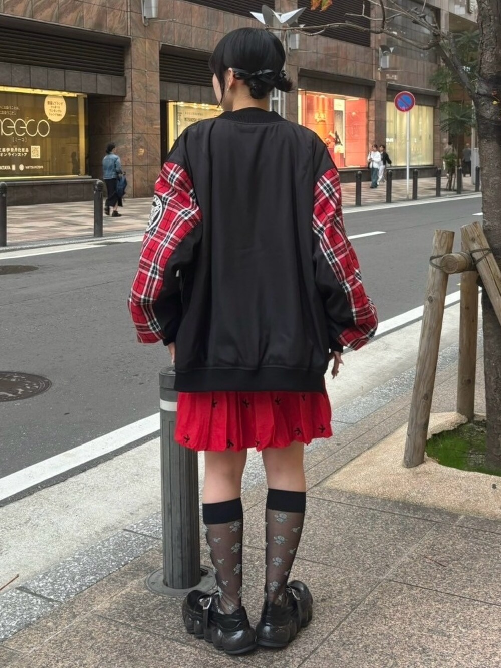 レッド系のスカート、ブラック系のニット/セーター、ブラック系のMA-1を着用したレディースの秋コーディネートの4枚目の写真