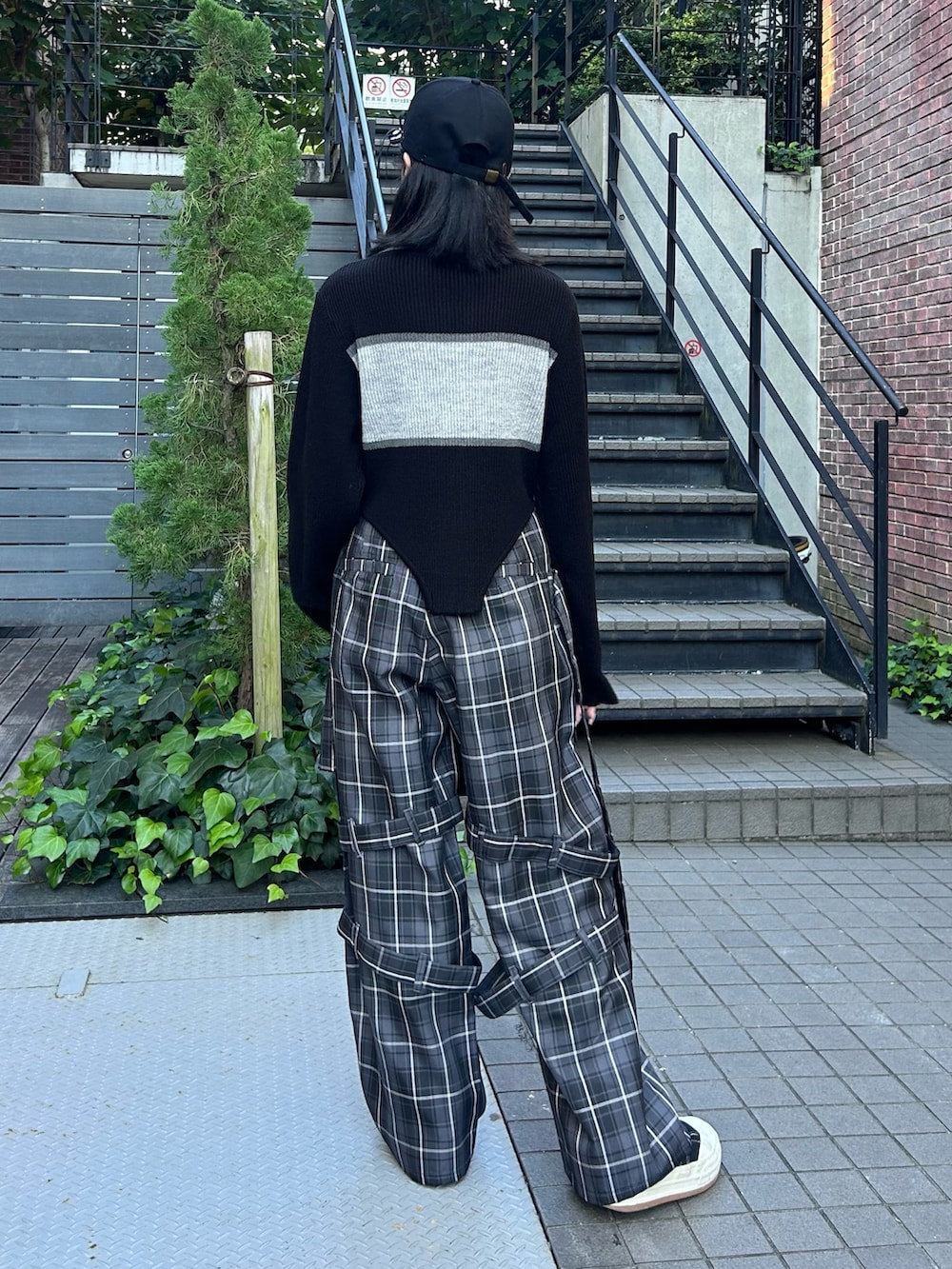 グレー系のその他パンツ、ブラック系のニット/セーター、ブラック系のキャップを着用したレディースの秋コーディネートの5枚目の写真