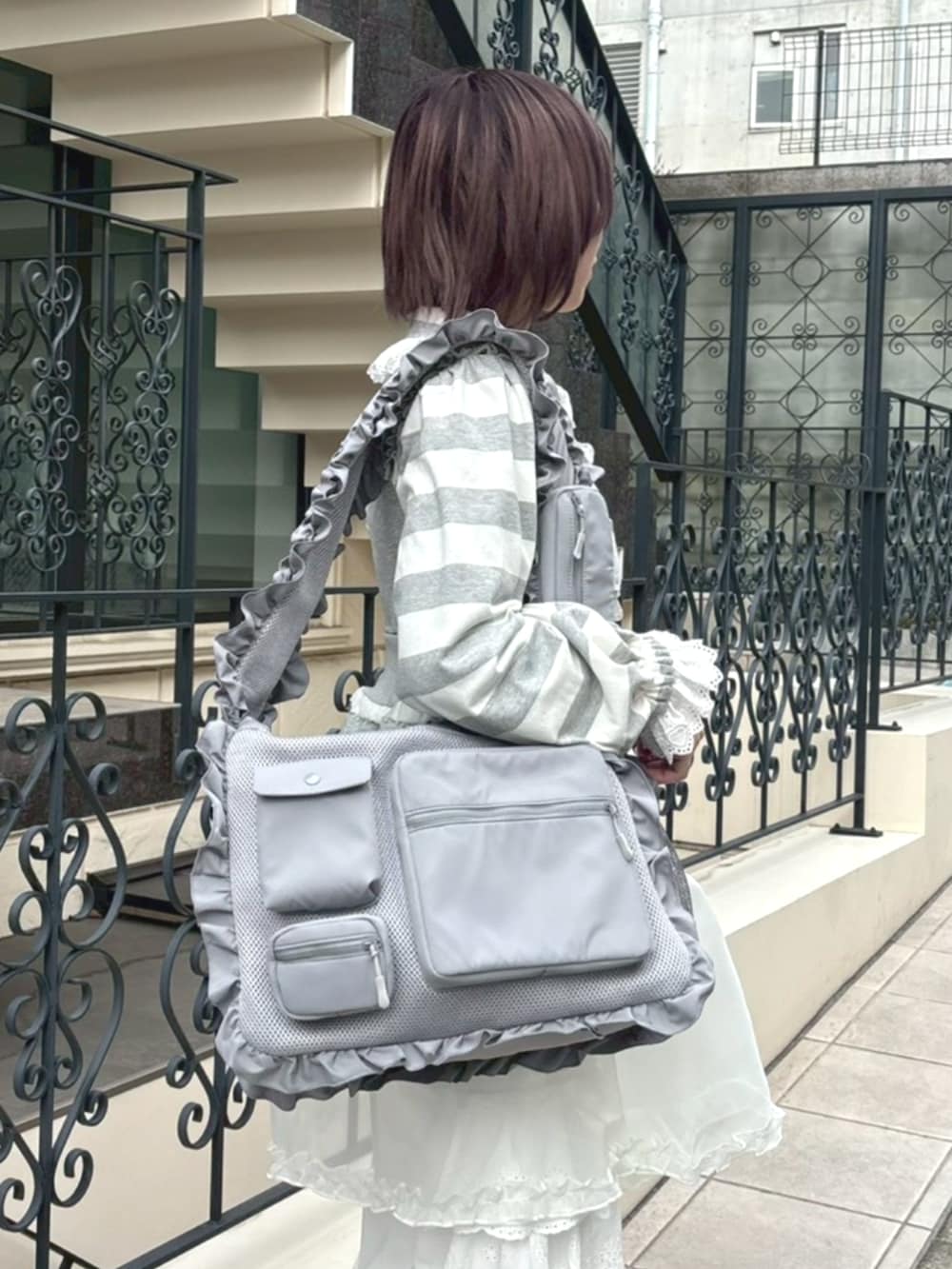 グレー系のショルダーバッグ、グレー系のワンピース、グレー系のその他トップスを着用したレディースの冬コーディネートの4枚目の写真