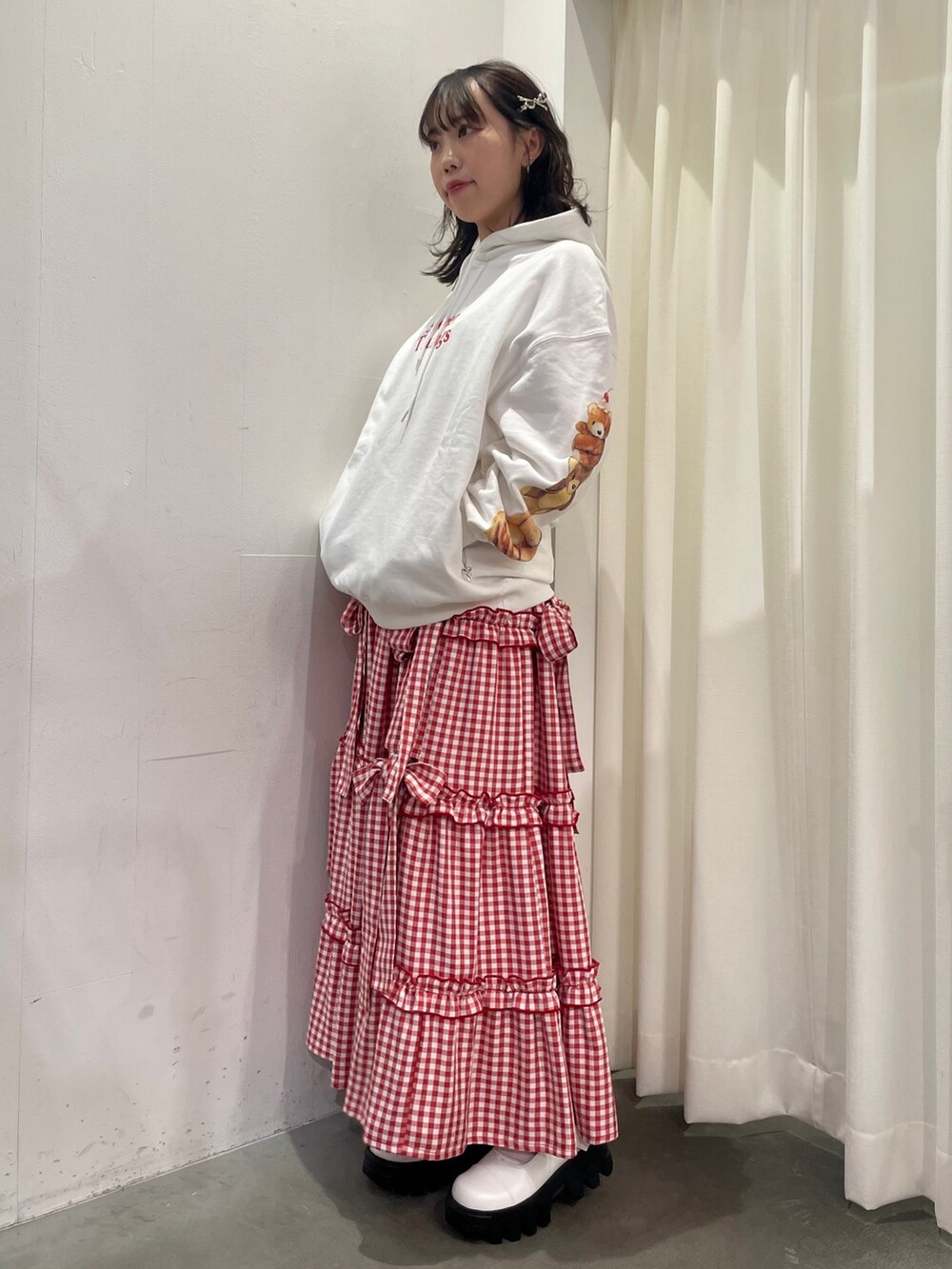 ホワイト系のブーツ、ホワイト系のスカート、ホワイト系のパーカーを着用したレディースの秋コーディネートの2枚目の写真
