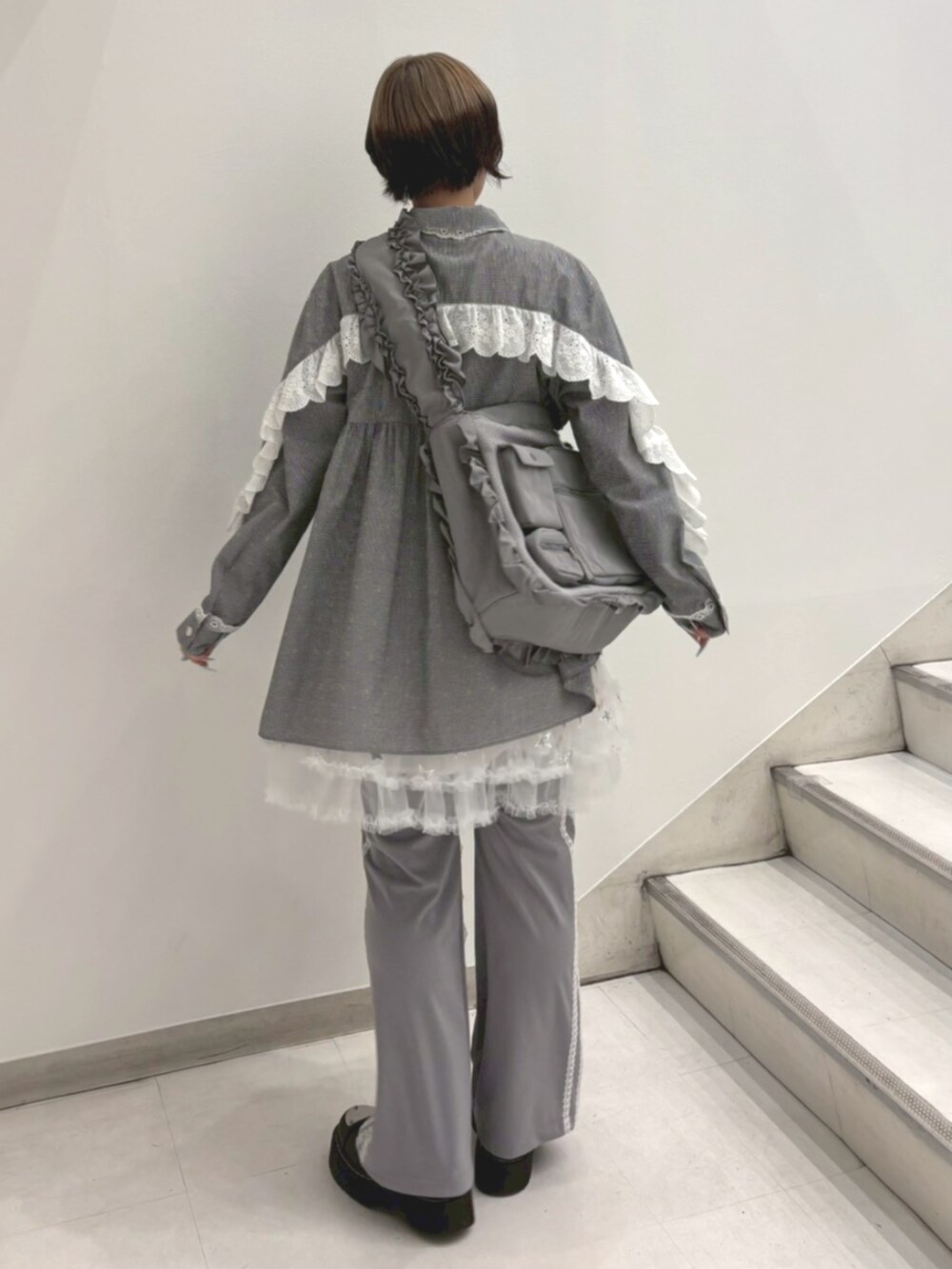 グレー系のその他パンツ、ホワイト系のスカート、グレー系のショルダーバッグを着用したレディースの春コーディネートの4枚目の写真
