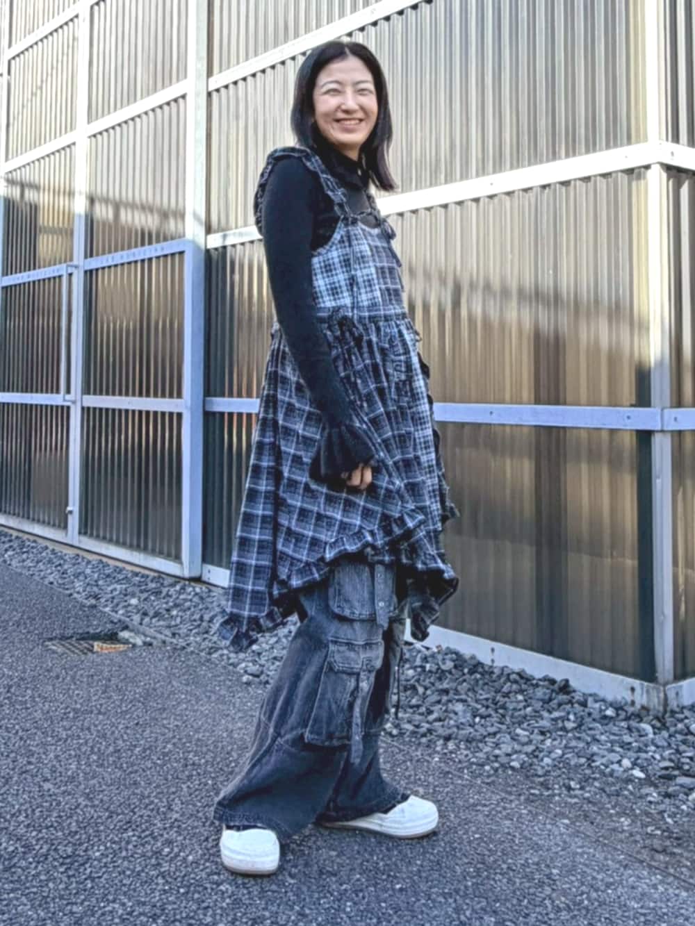 ブラック系のデニムパンツ、ブラック系のワンピース、ブラック系のニット/セーターを着用したレディースの冬コーディネートの2枚目の写真