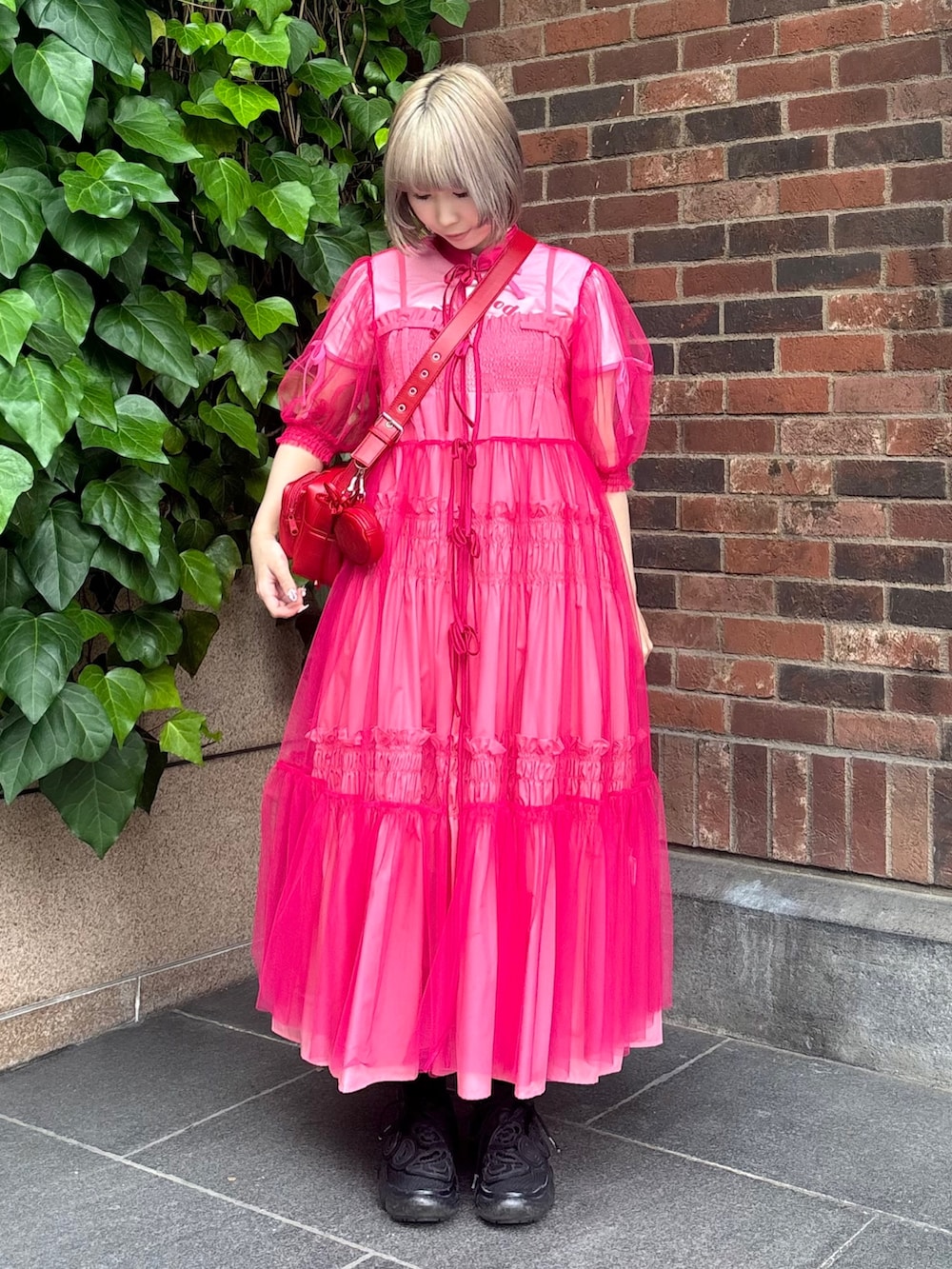 レッド系のショルダーバッグ、ピンク系のTシャツ/カットソー、ピンク系のワンピースを着用したレディースの夏コーディネートの3枚目の写真