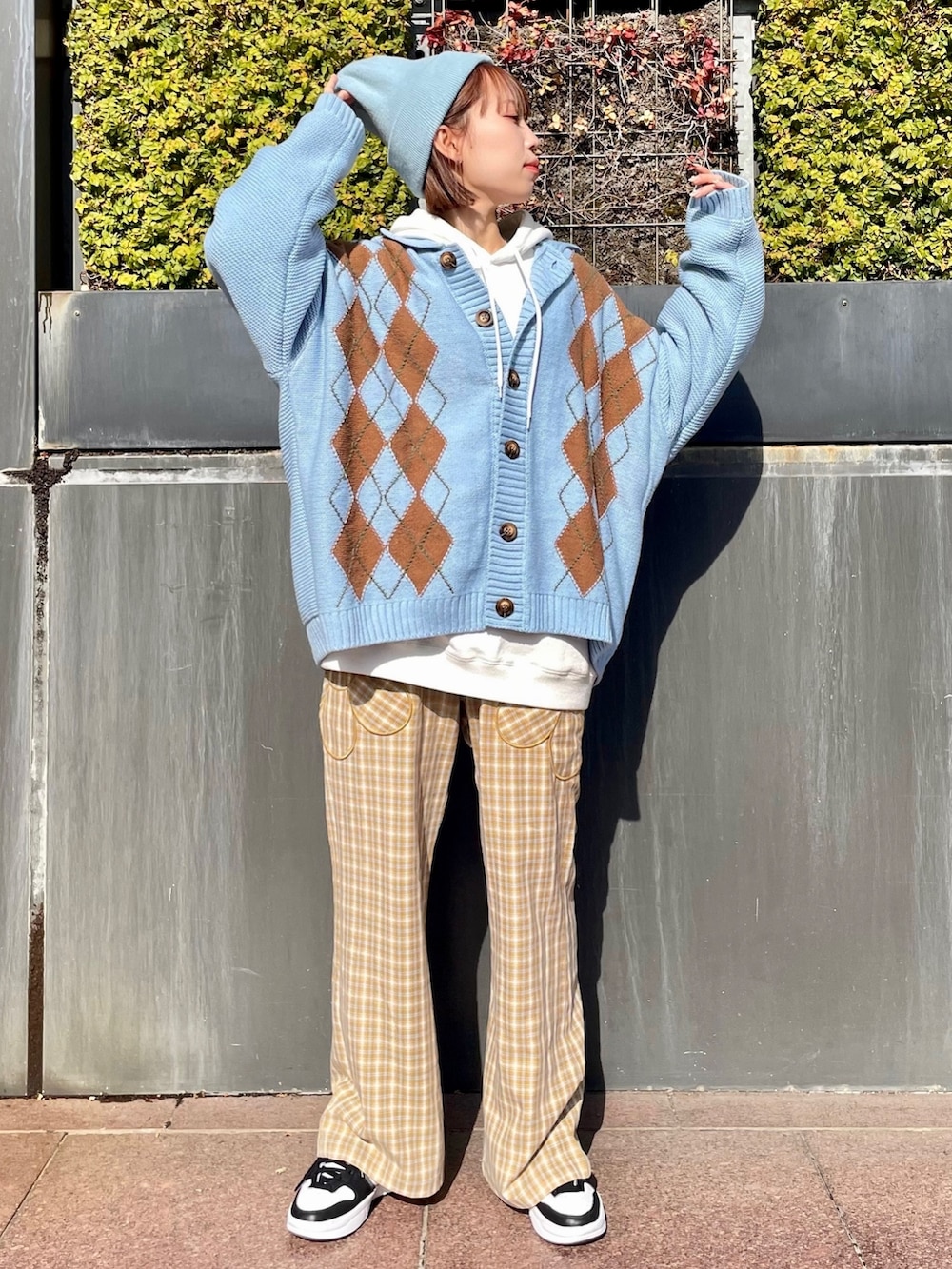 ベージュ系のその他パンツ、ブルー系のカーディガン/ボレロ、ホワイト系のスウェットを着用したレディースの冬コーディネートの2枚目の写真