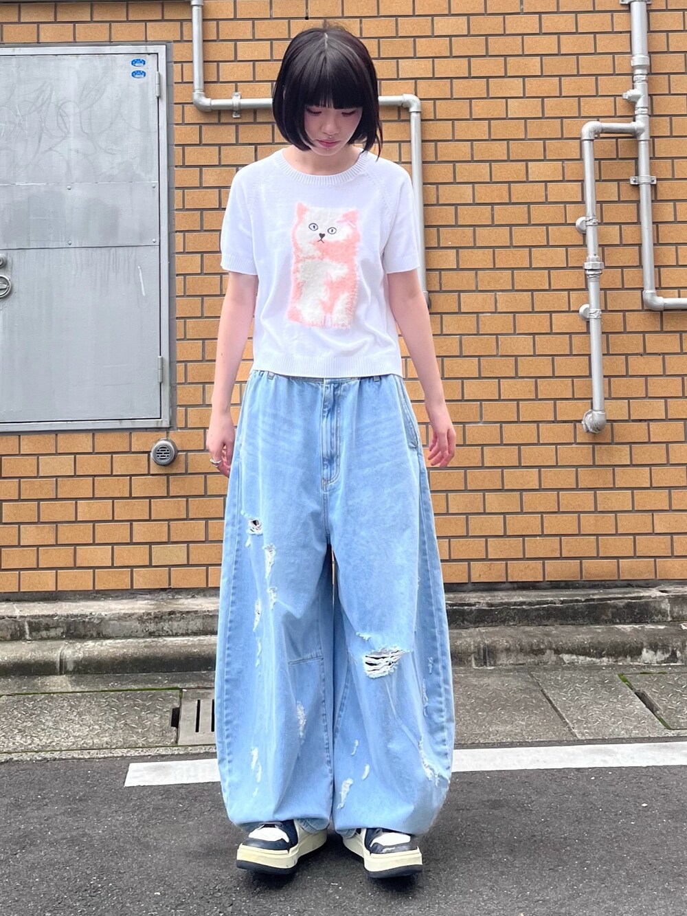 ブルー系のデニムパンツ、ホワイト系のニット/セーターを着用したレディースの夏コーディネートの2枚目の写真