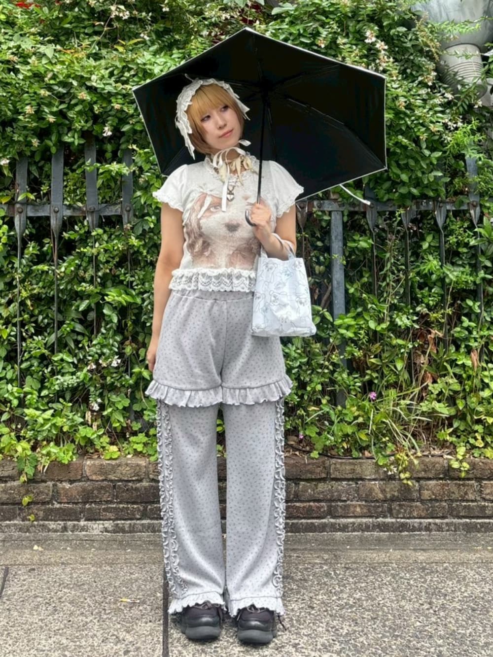 グレー系のその他パンツ、ホワイト系のTシャツ/カットソー、ホワイト系の折りたたみ傘を着用したレディースの夏コーディネートの2枚目の写真