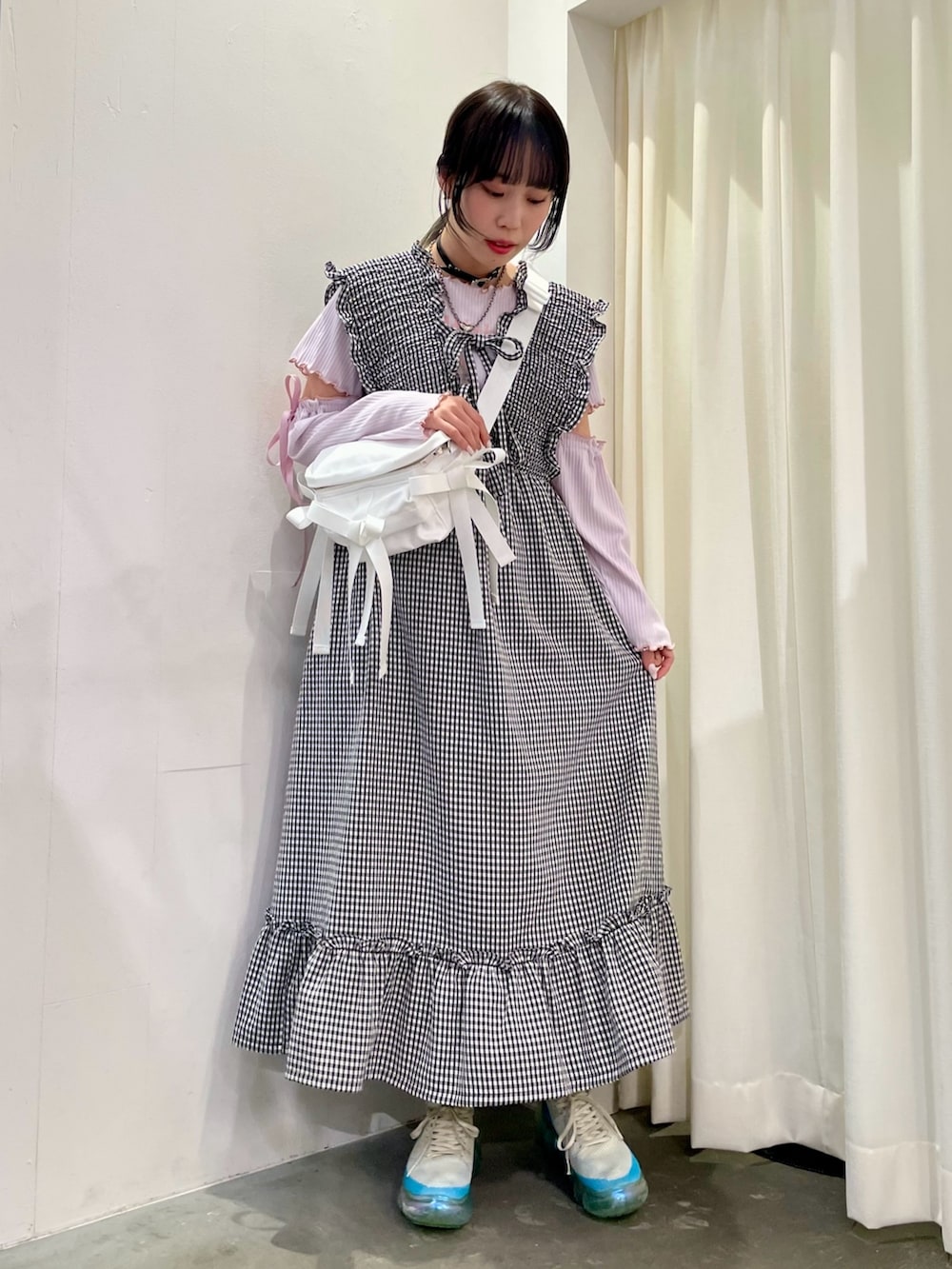 ピンク系のその他トップス、ホワイト系のジャンパースカート、ホワイト系のボディバッグ/ウエストポーチを着用したレディースの春コーディネートの2枚目の写真