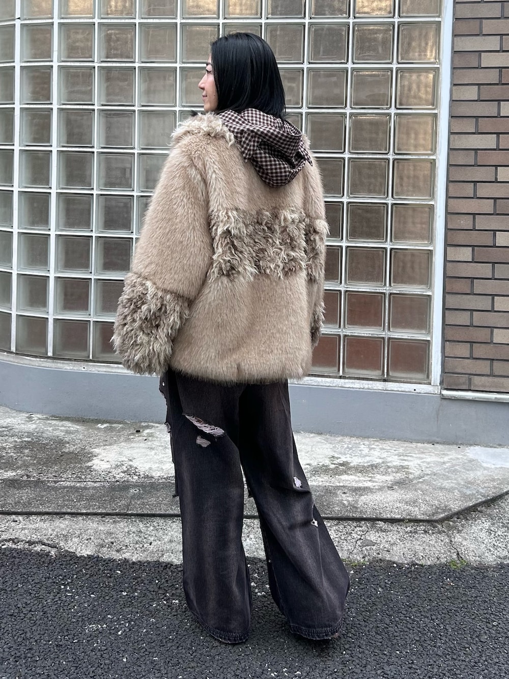 ブラック系のデニムパンツ、ブラウン系のシャツ/ブラウス、ベージュ系のダウンジャケット/コートを着用したレディースの冬コーディネートの6枚目の写真