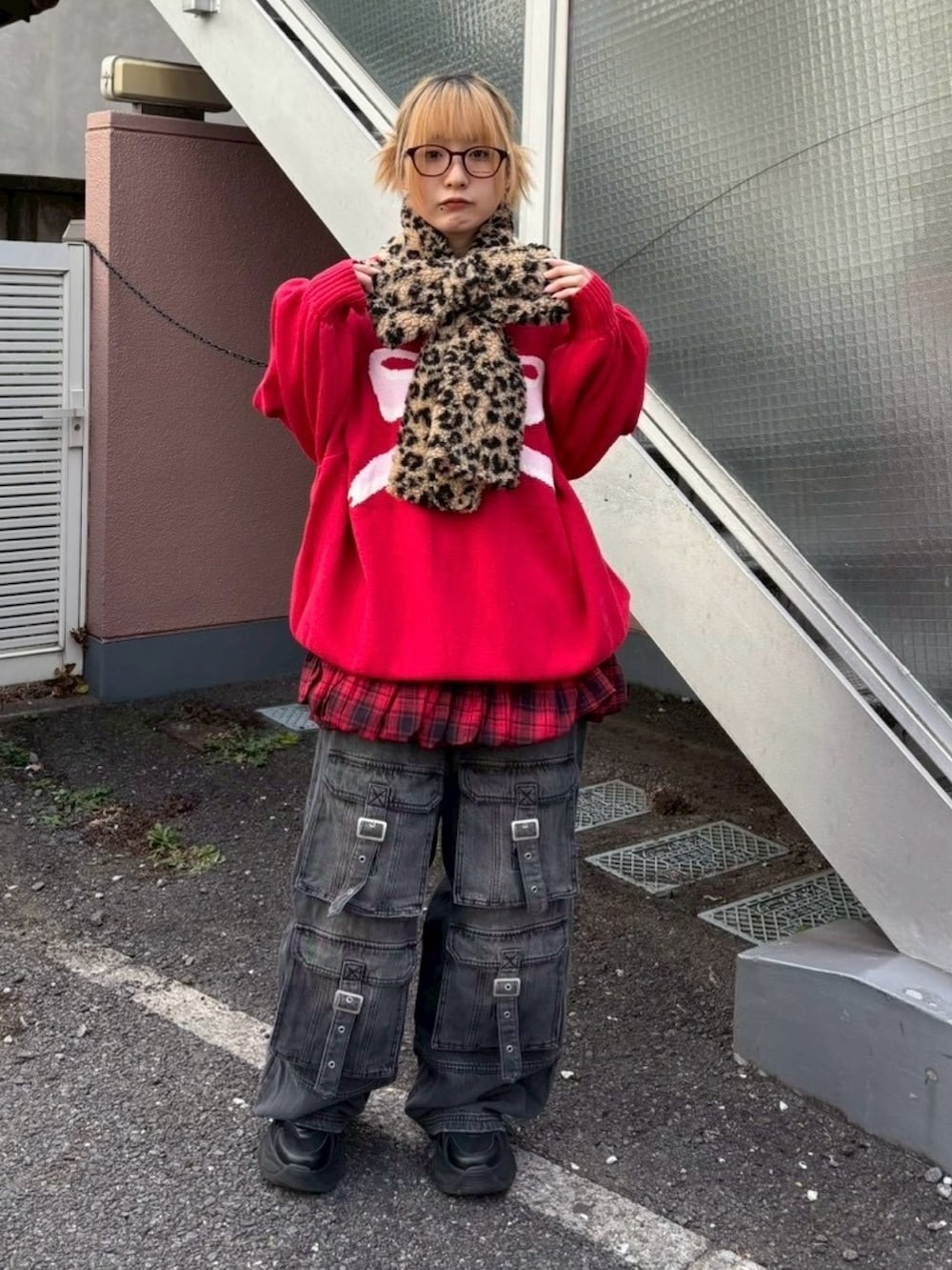 ブラック系のデニムパンツ、レッド系のスカート、レッド系のニット/セーターを着用したレディースの冬コーディネートの3枚目の写真