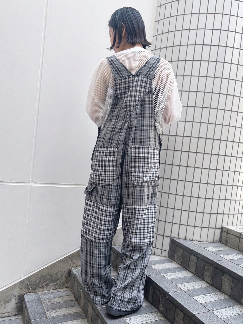 ブラック系のサロペット/オーバーオール、ホワイト系のTシャツ/カットソーを着用したレディースの夏コーディネートの3枚目の写真