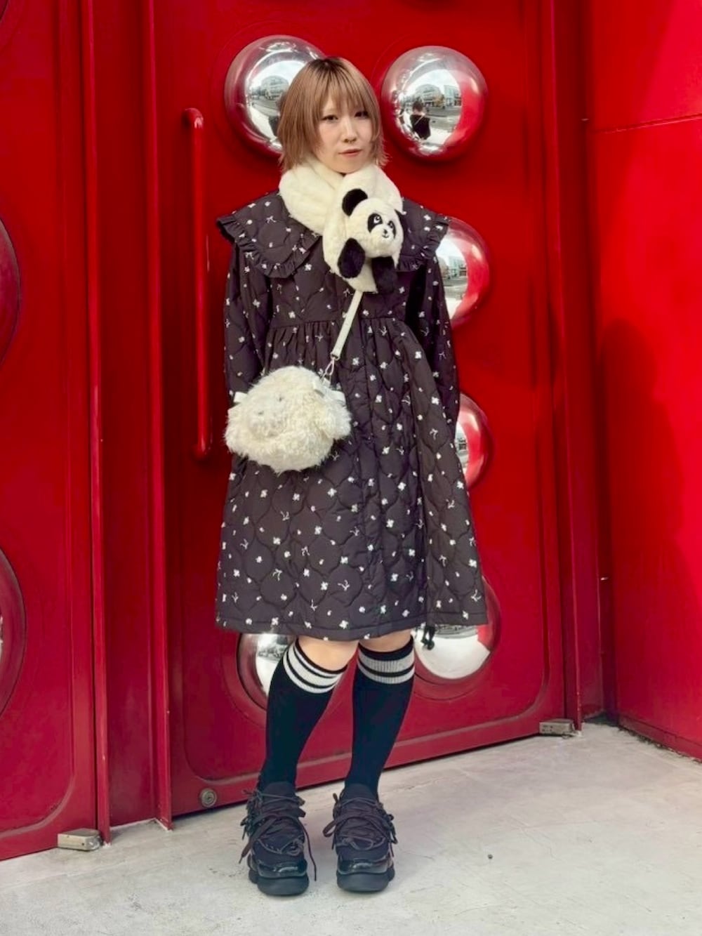 ホワイト系のショルダーバッグ、ブラック系のダウンジャケット/コート、ブラック系のソックス/靴下を着用したレディースの冬コーディネートの3枚目の写真