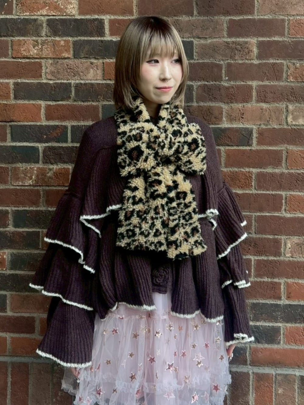 ブラウン系のカーディガン/ボレロ、ピンク系のスカート、ベージュ系のマフラーを着用したレディースの冬コーディネートの3枚目の写真