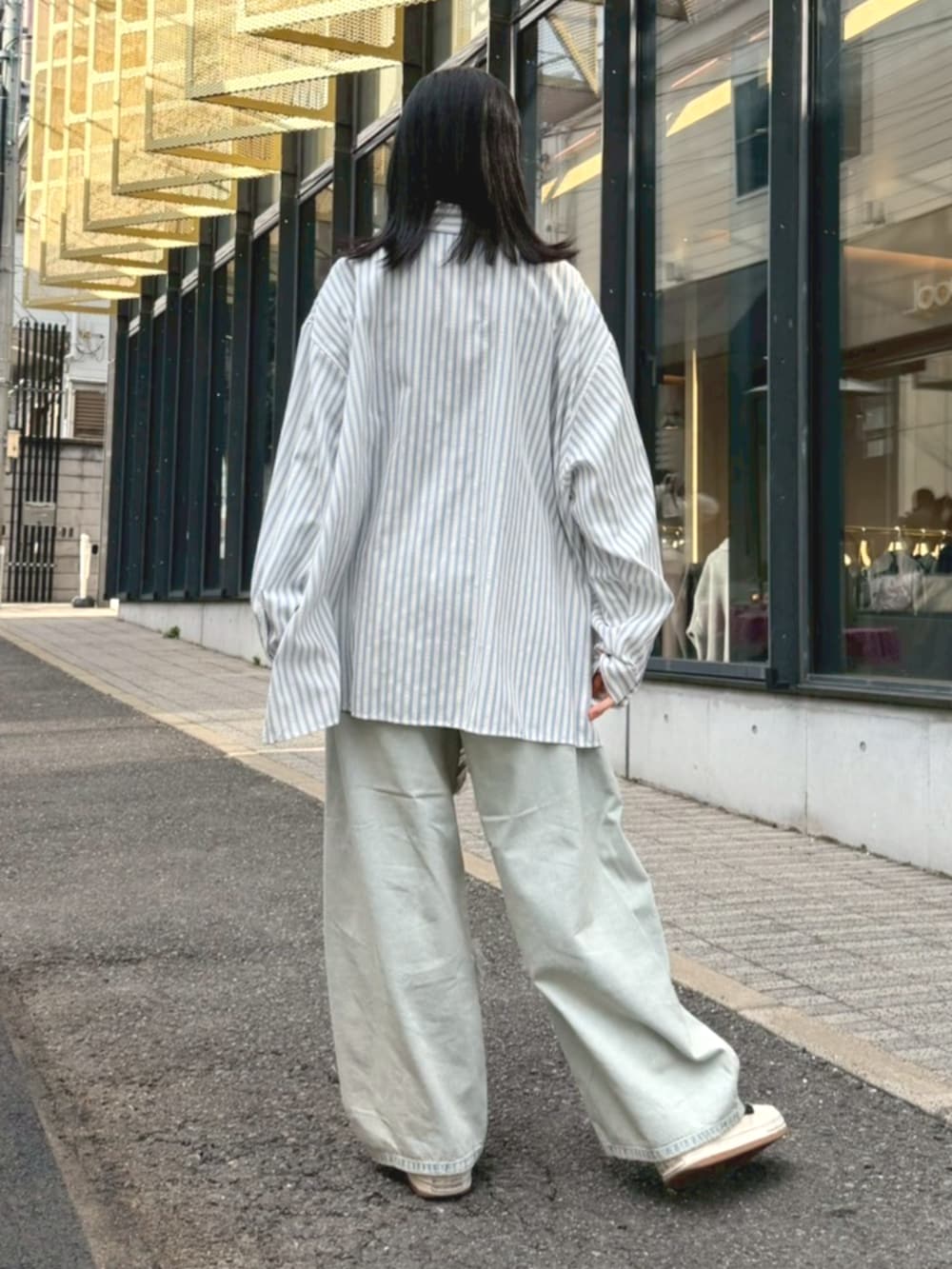 ブルー系のシャツ/ブラウス、グレー系のショルダーバッグ、ブルー系のデニムパンツを着用したレディースの冬コーディネートの3枚目の写真