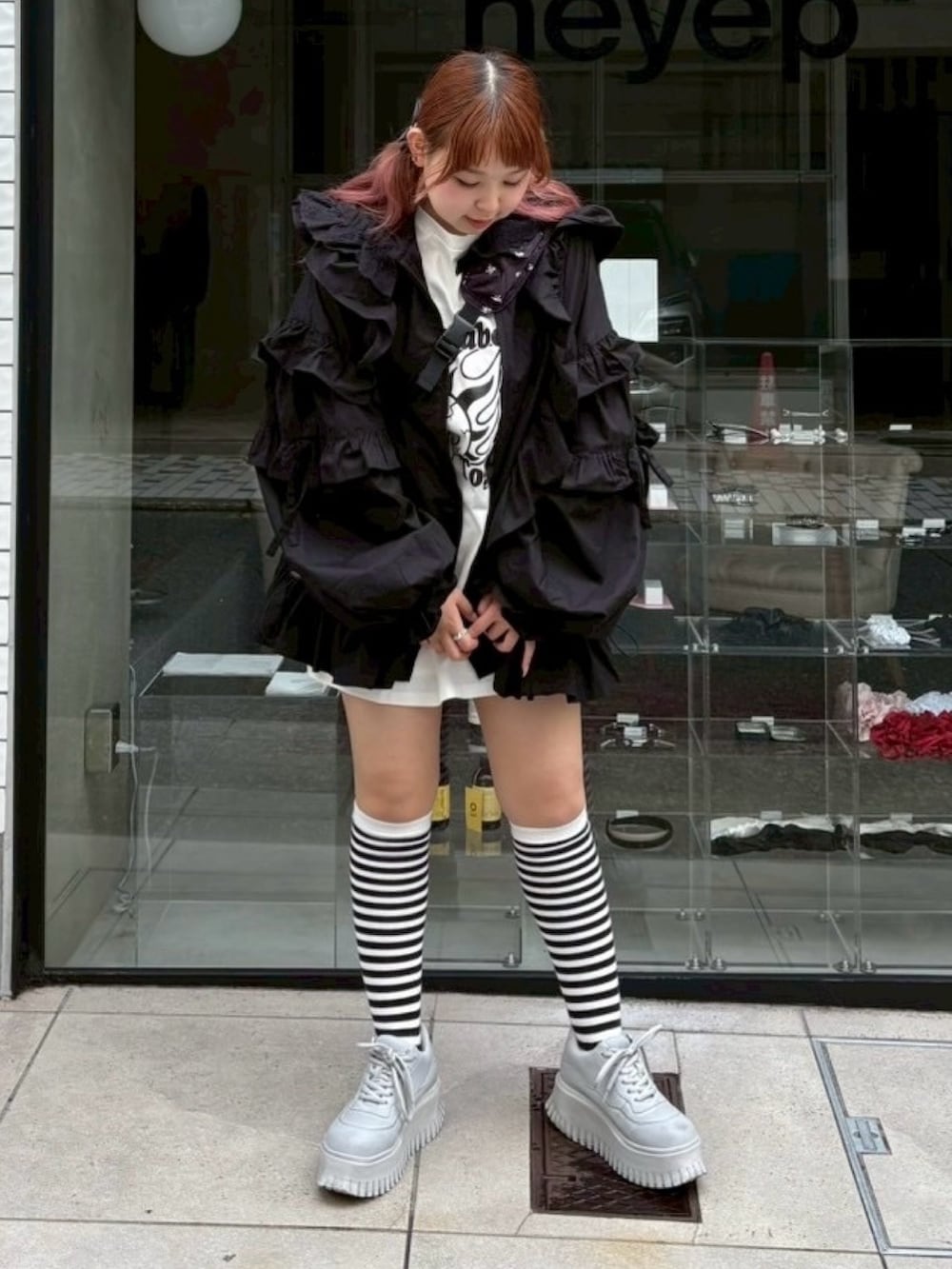 ブラック系のショルダーバッグ、ホワイト系のTシャツ/カットソー、ブラック系のブルゾンを着用したレディースの秋コーディネートの2枚目の写真