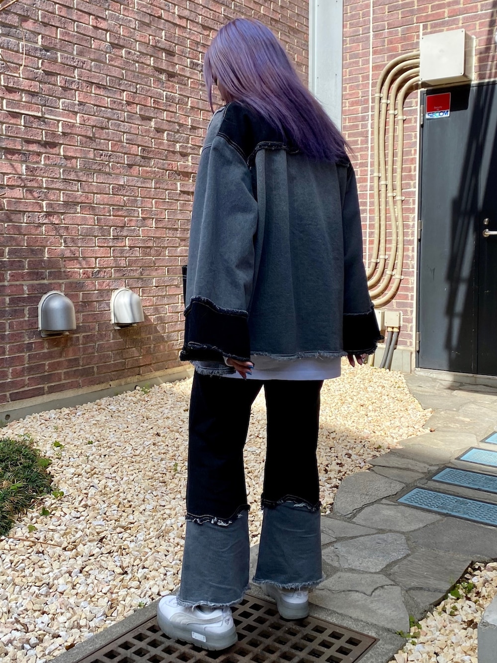 ブラック系のデニムパンツ、ブラック系のデニムジャケット、ホワイト系のTシャツ/カットソーを着用したレディースの春コーディネートの5枚目の写真