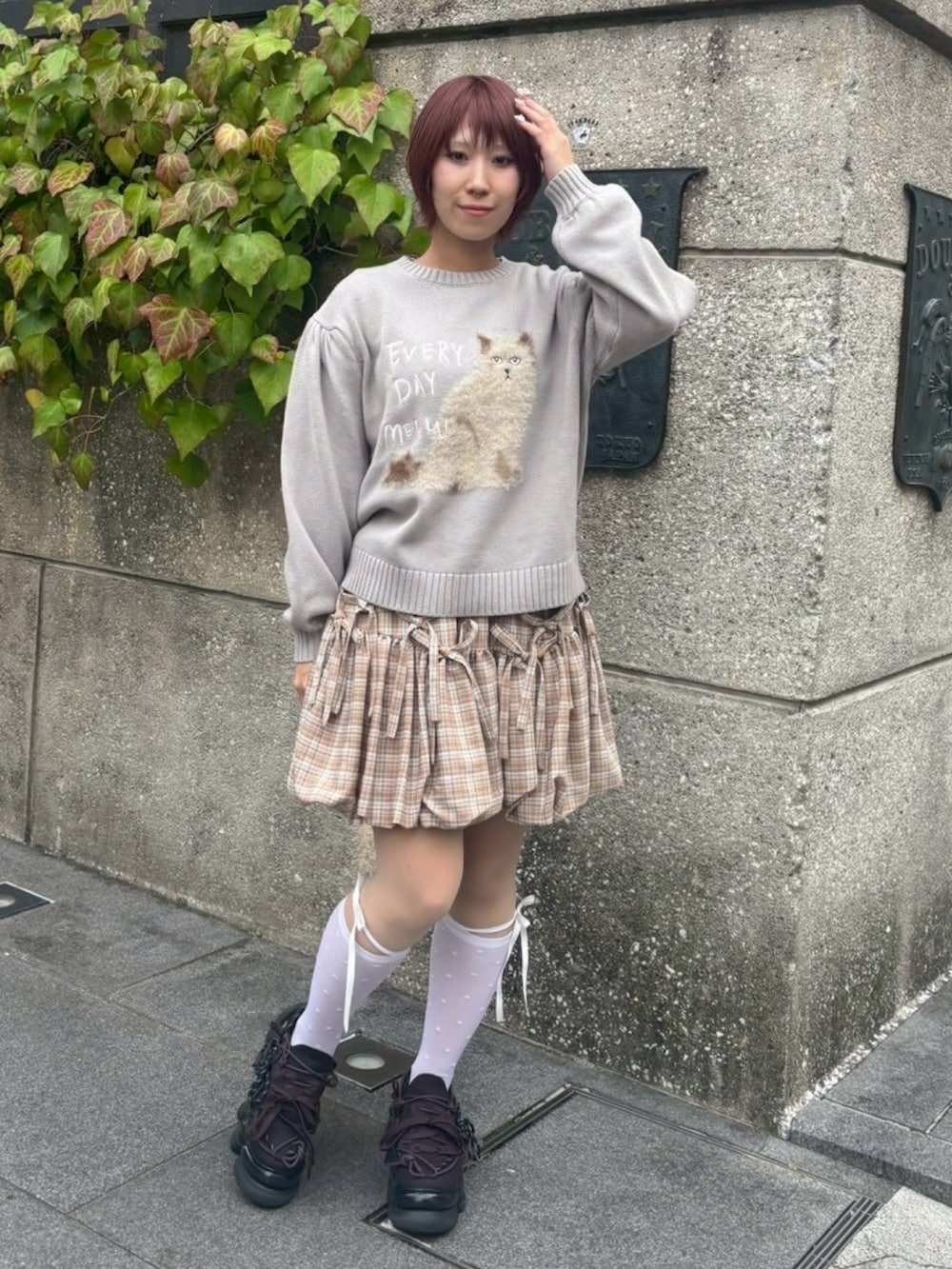 グレー系のニット/セーター、ベージュ系のスカート、ホワイト系のソックス/靴下を着用したレディースの秋コーディネートの2枚目の写真